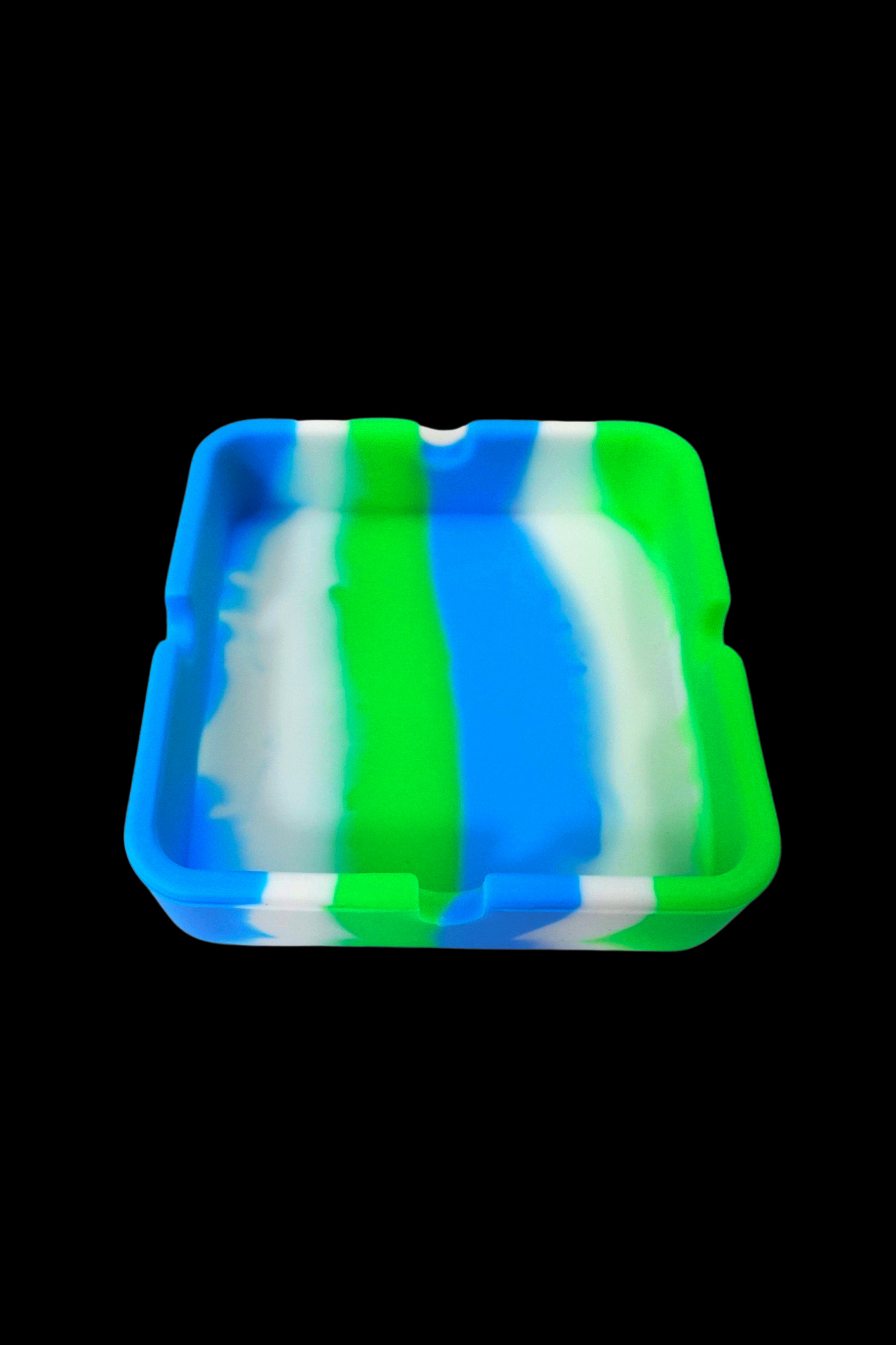 Blue and green silicone hash tray isolated on a black background.