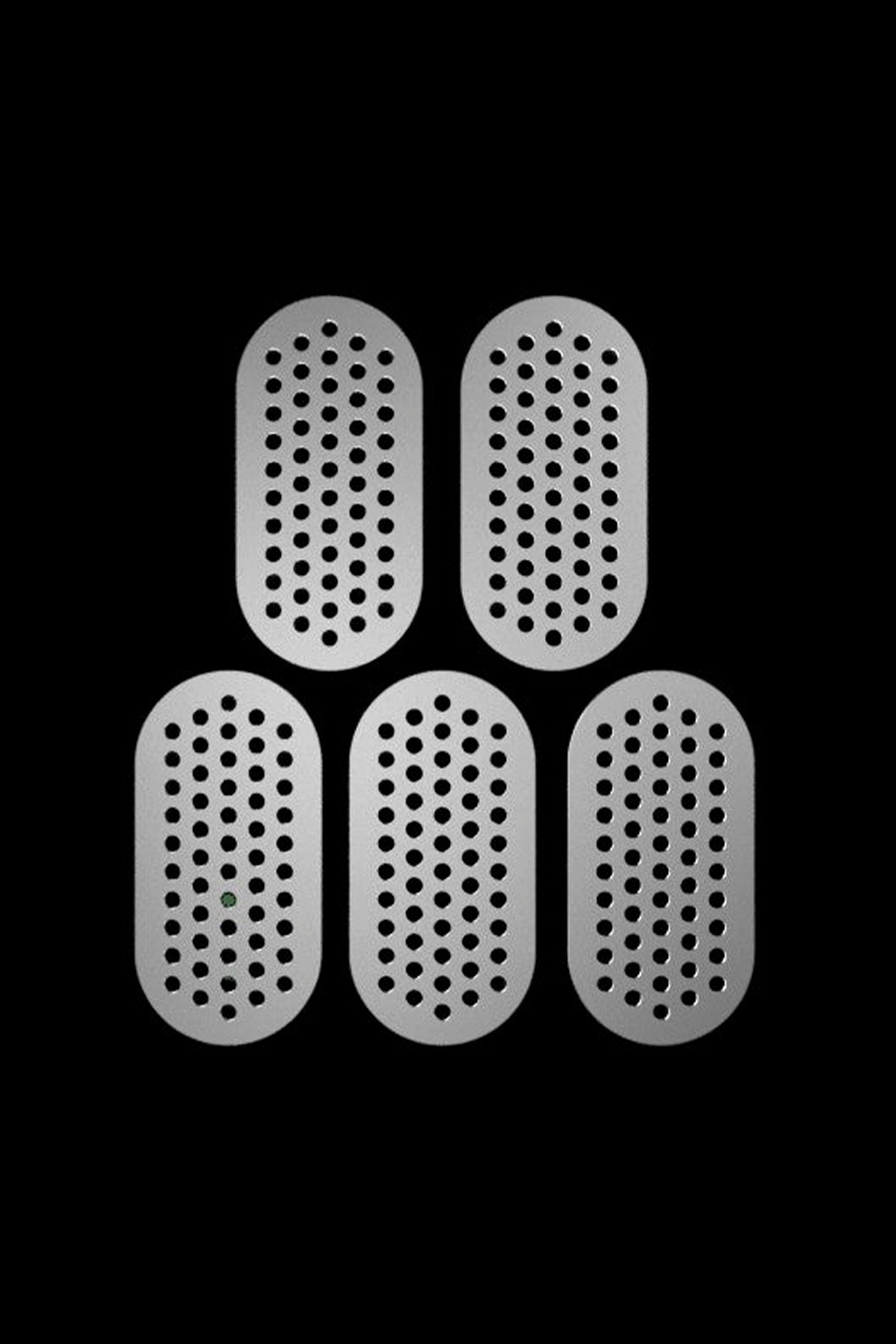 Five perforated metal screens for cannabis bowls, arranged against a black background.