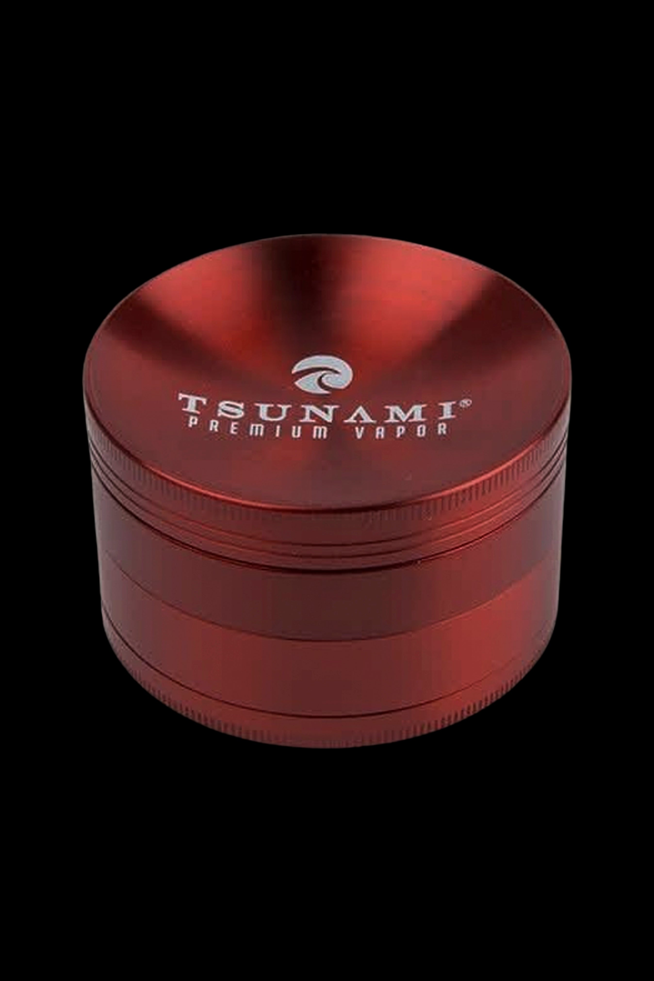Red four-piece cannabis grinder with “TSUNAMI PREMIUM VAPOR” logo.