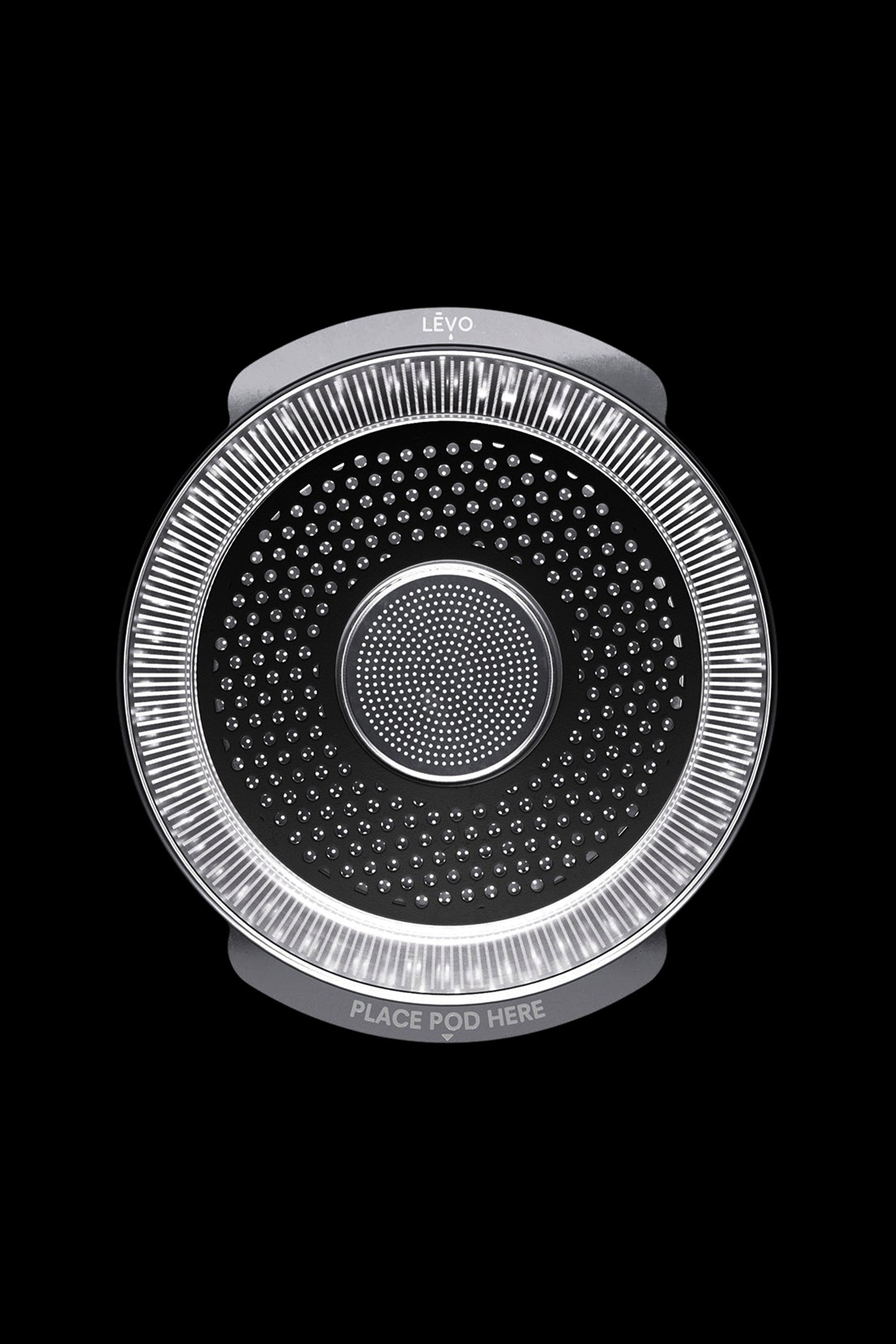 A Levo oil infusion device with a perforated stainless steel basket and illuminated ring, designed for cannabis or herbal extracts.