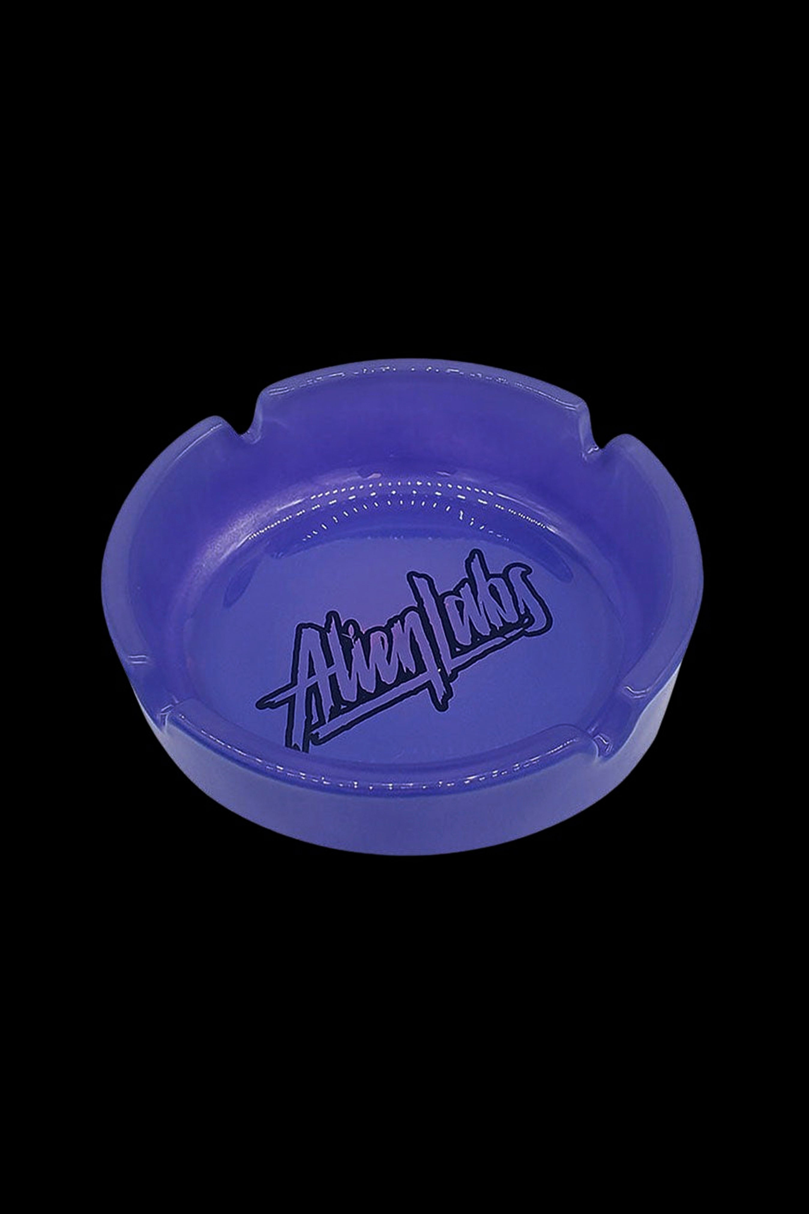 Blue glass ashtray with “Alien Labs” logo.