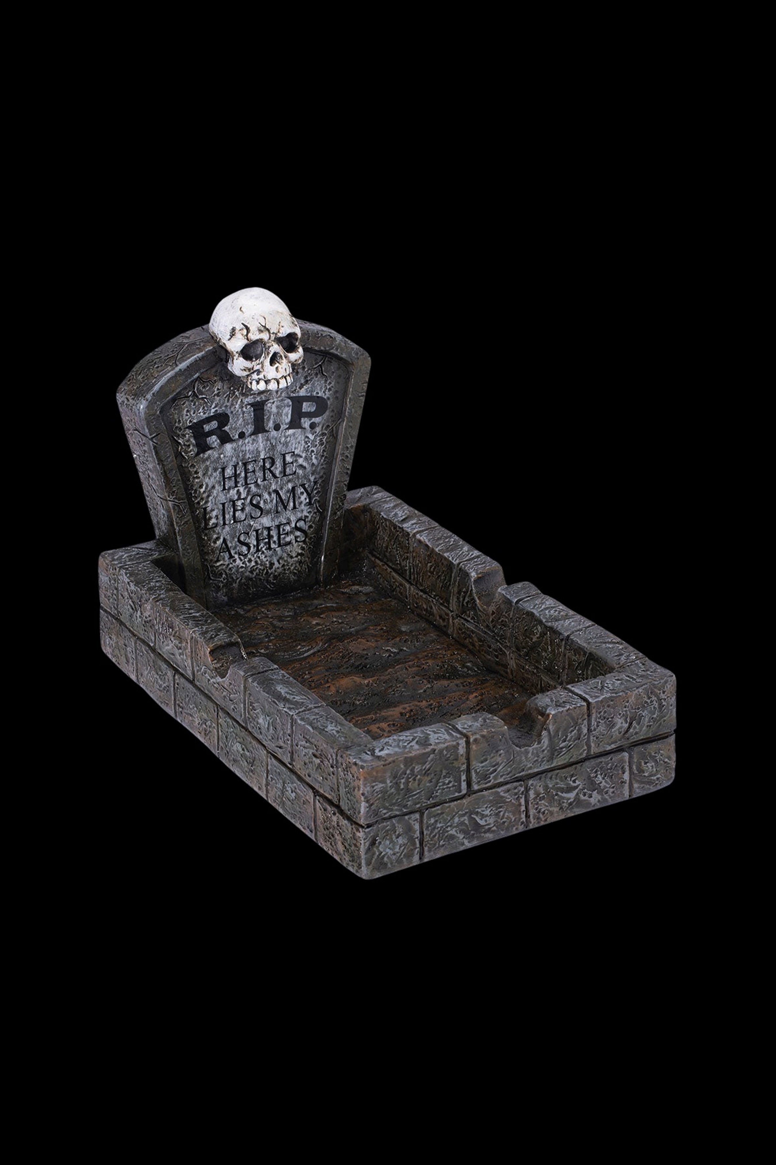 A Halloween-themed ashtray shaped like a graveyard plot, with a skull and "RIP HERE LIES MY ASHES" inscribed on a tombstone.