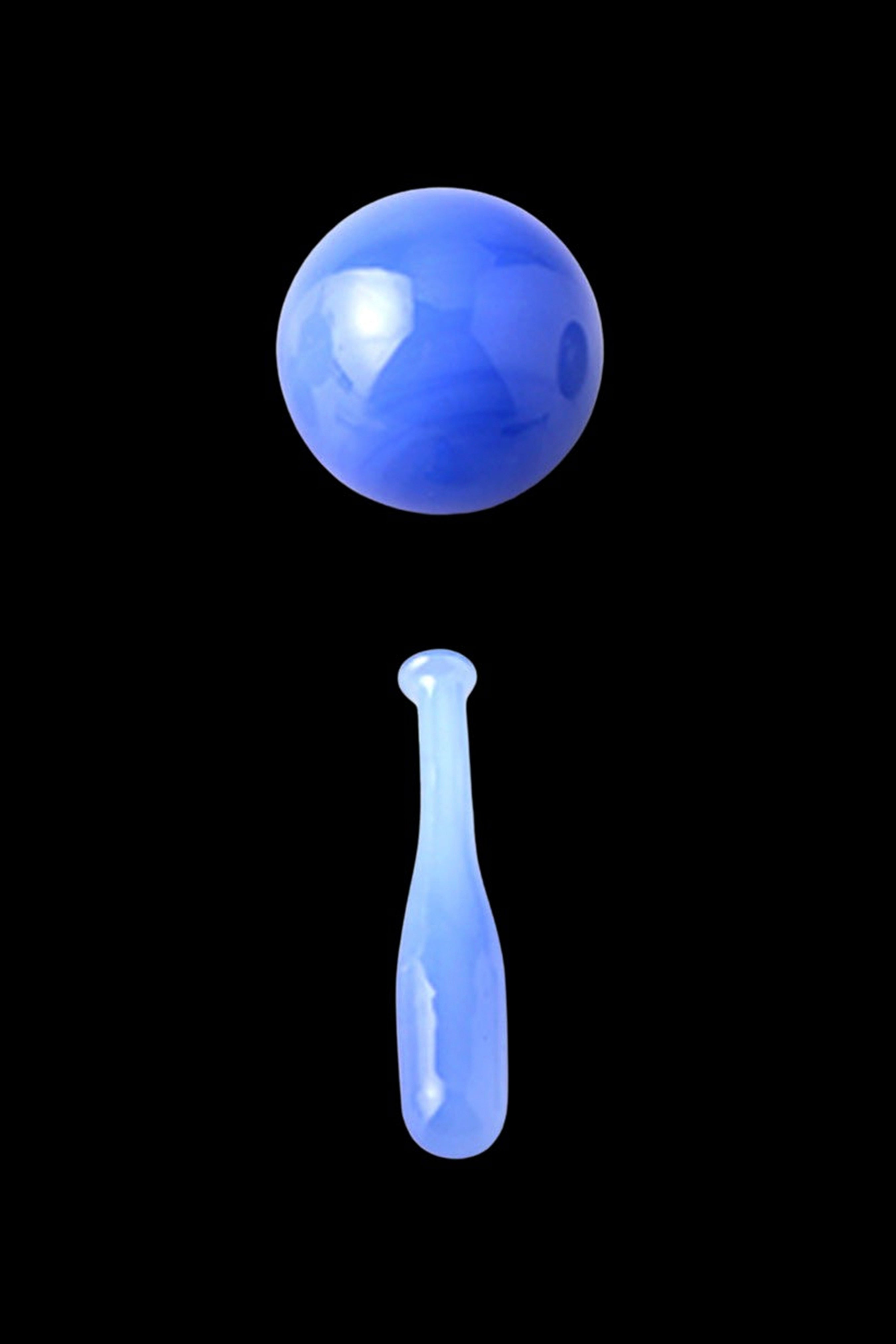 Blue glass cannabis oil droplet suspended above a rig nail.