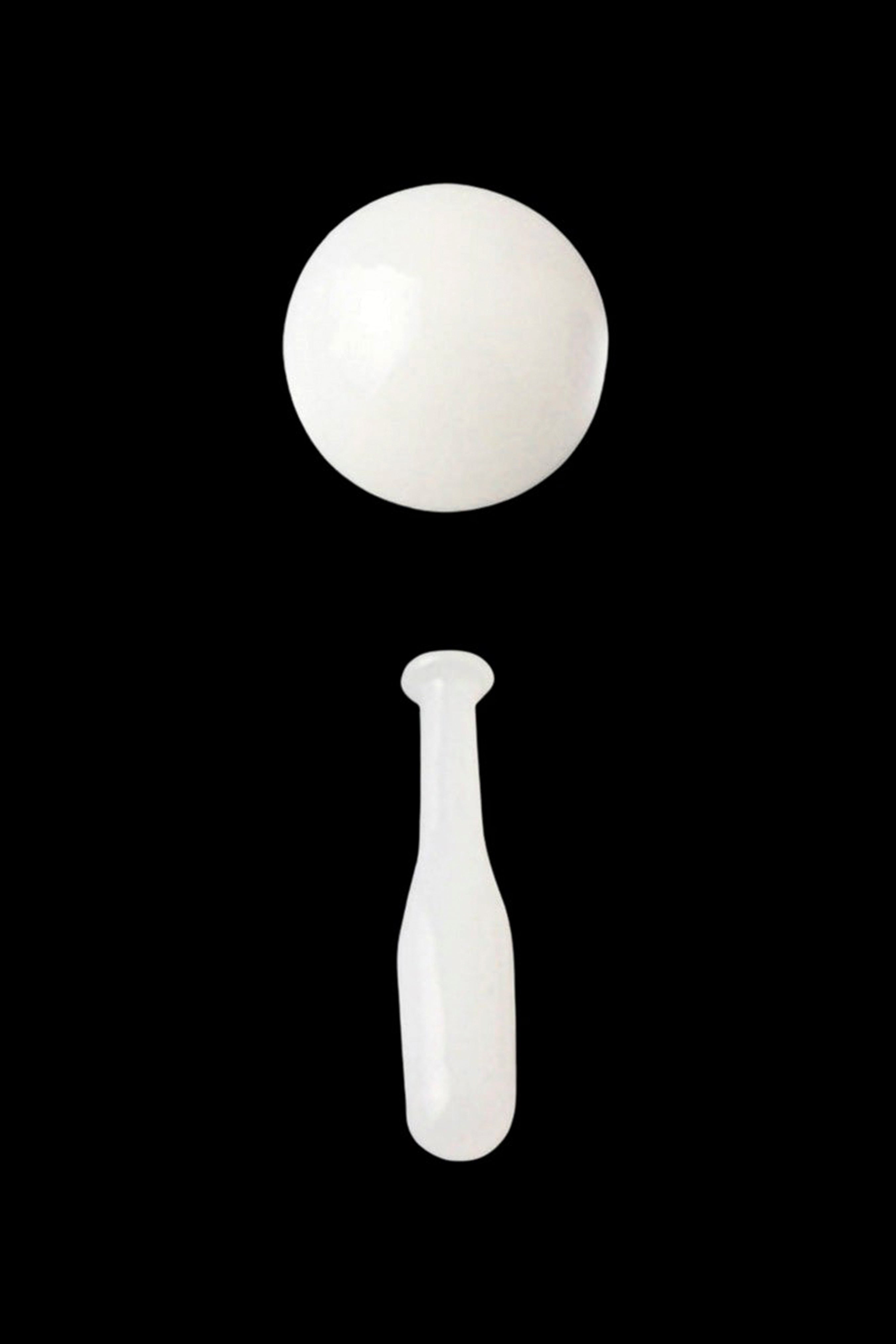 White dab tool with a spherical end and tapered stem against a black background.