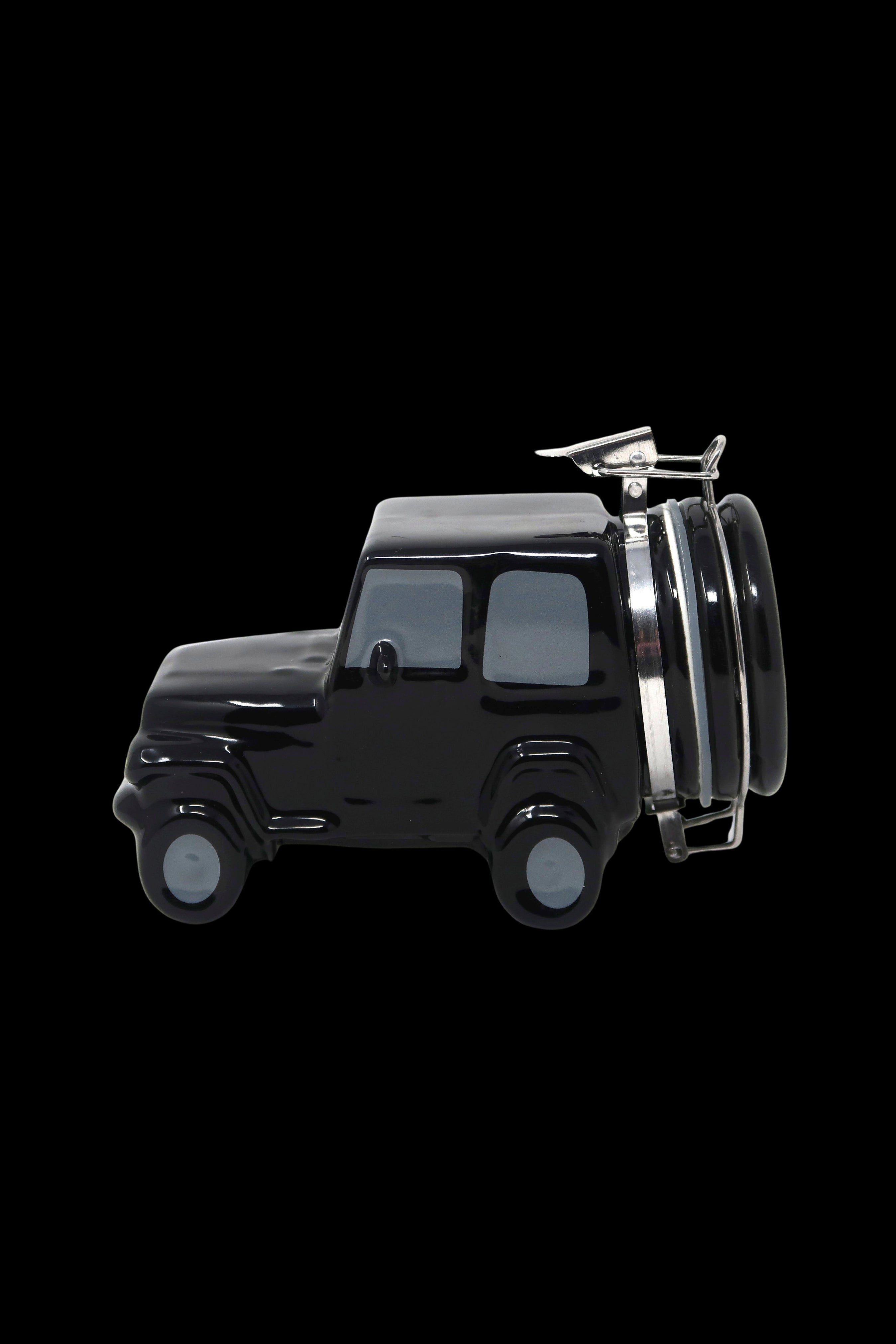 Black ceramic cannabis grinder shaped like a vintage SUV with a chrome rack and glass chamber.