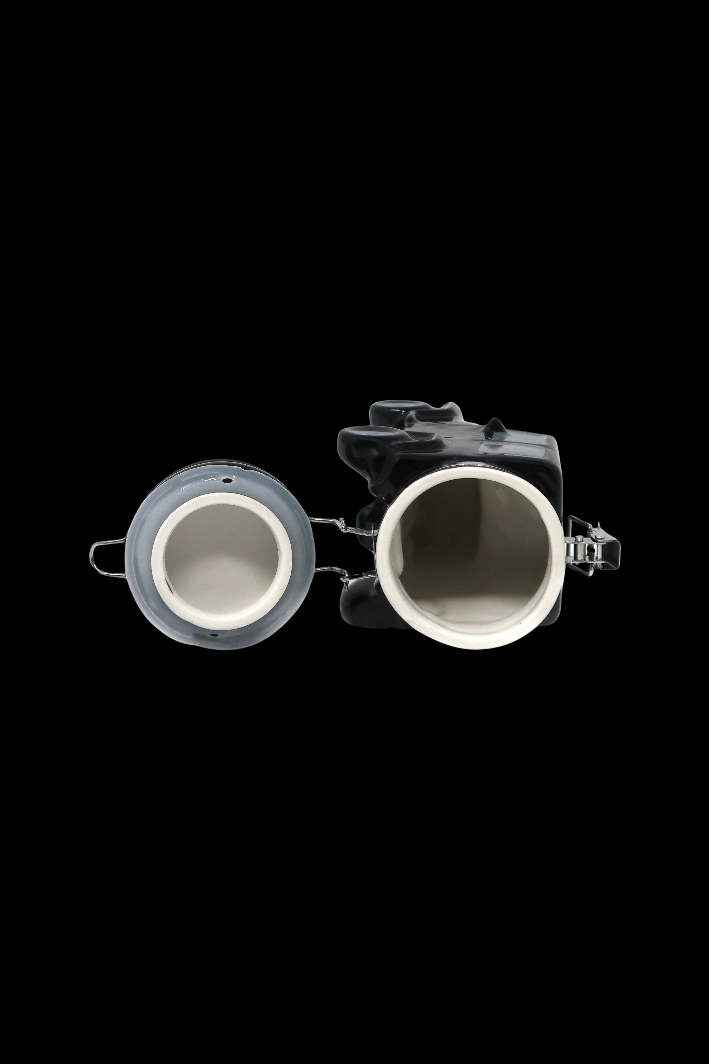 Overhead view of a transparent cannabis grinder with two chambers, isolated on a black background.