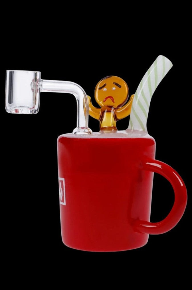 Red glass dab rig shaped like a coffee mug with a sad, cartoon figure on top and a quartz nail extending from the side.