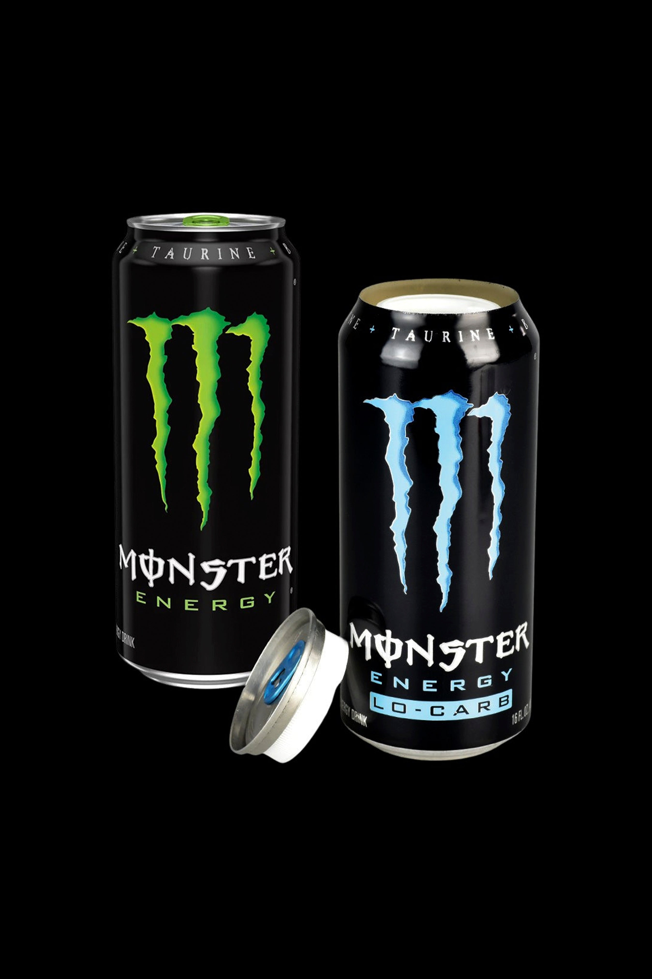 Two Monster Energy drinks, one closed and one open revealing a silver smoking bowl inside, on a black background.