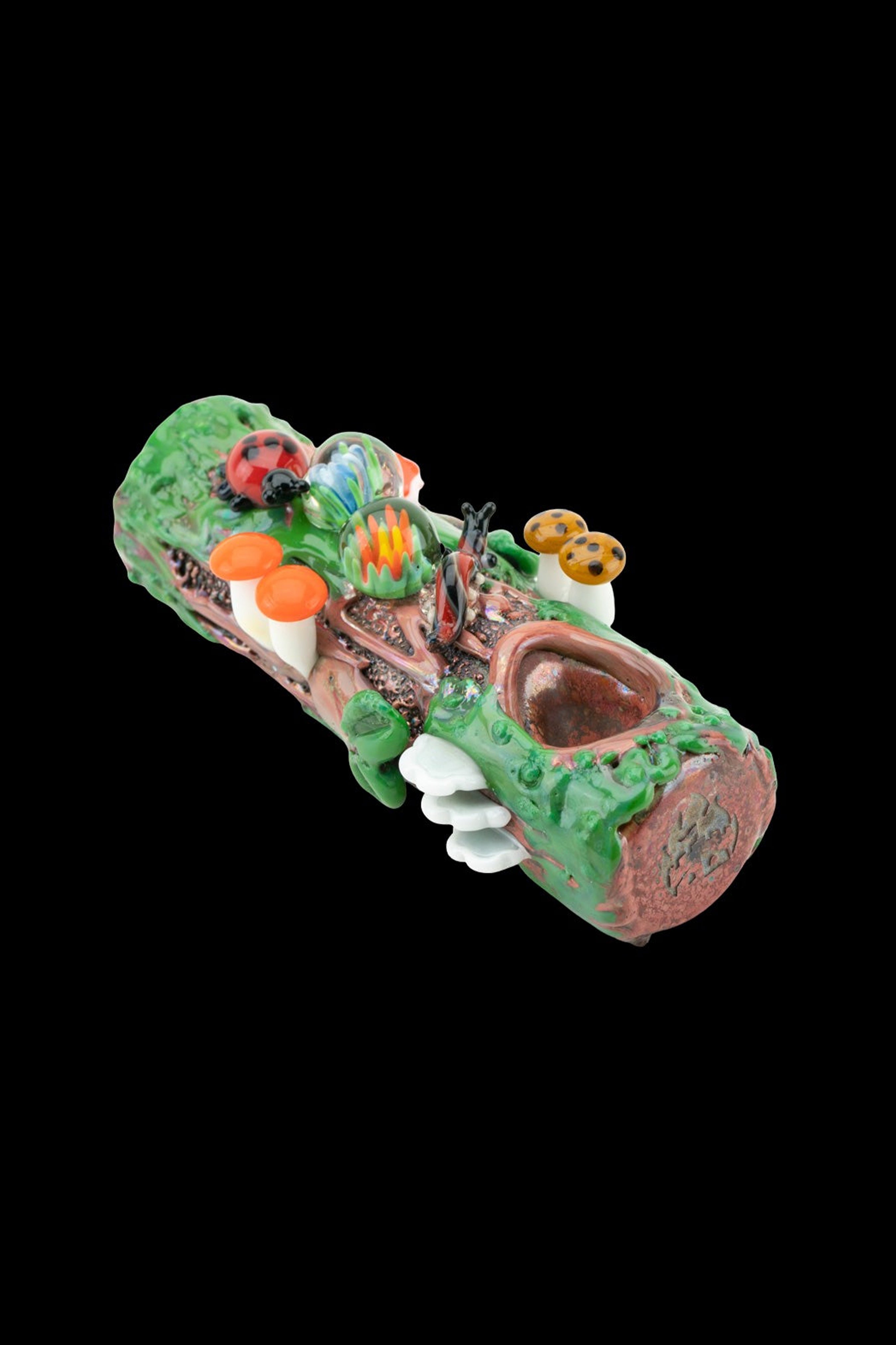 Hand-blown glass pipe sculpted as a whimsical forest log with colorful mushrooms, flowers, and a smiling face.