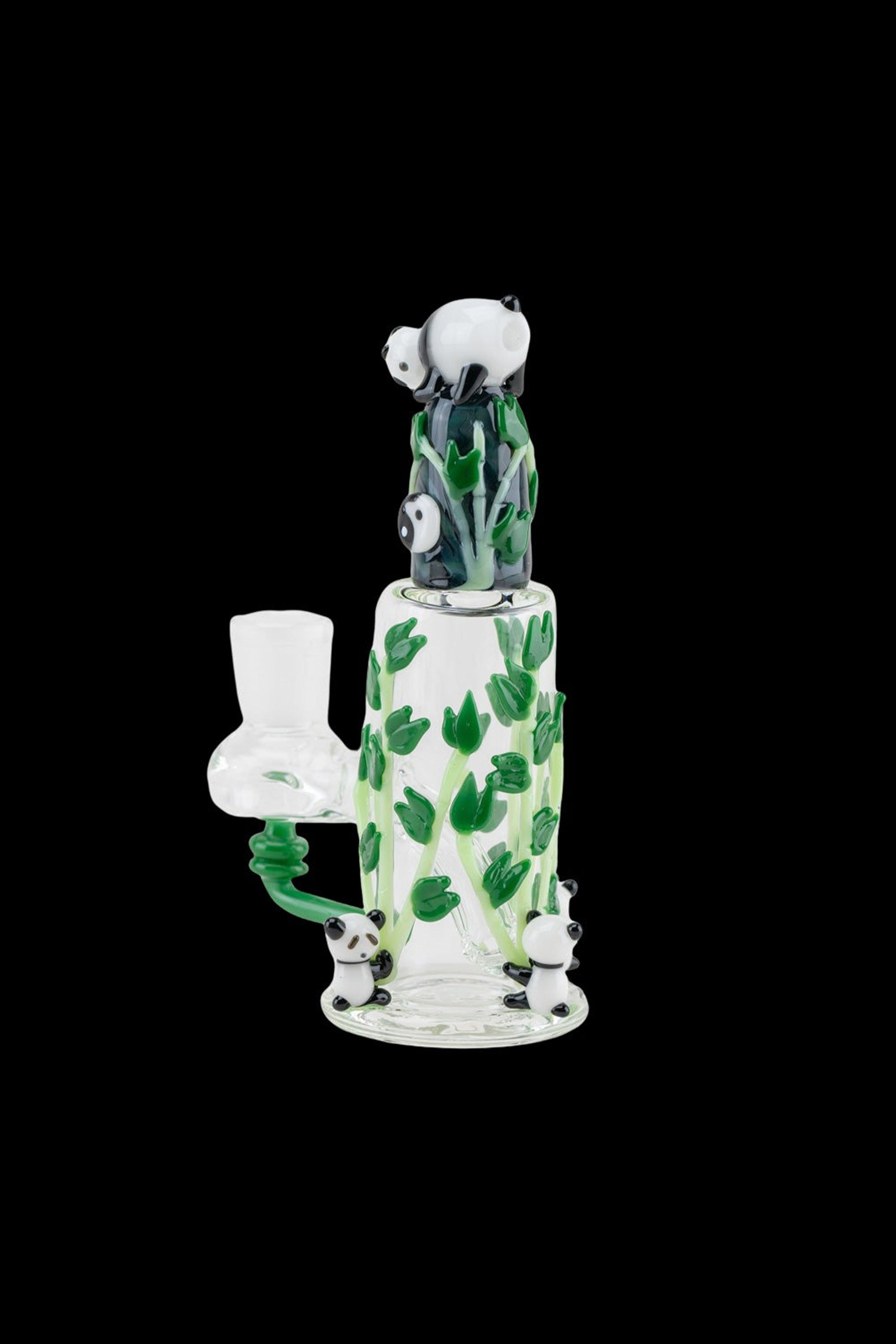 A white glass water pipe decorated with green leaves and playful panda faces, featuring a panda-shaped mouthpiece and bubbler.