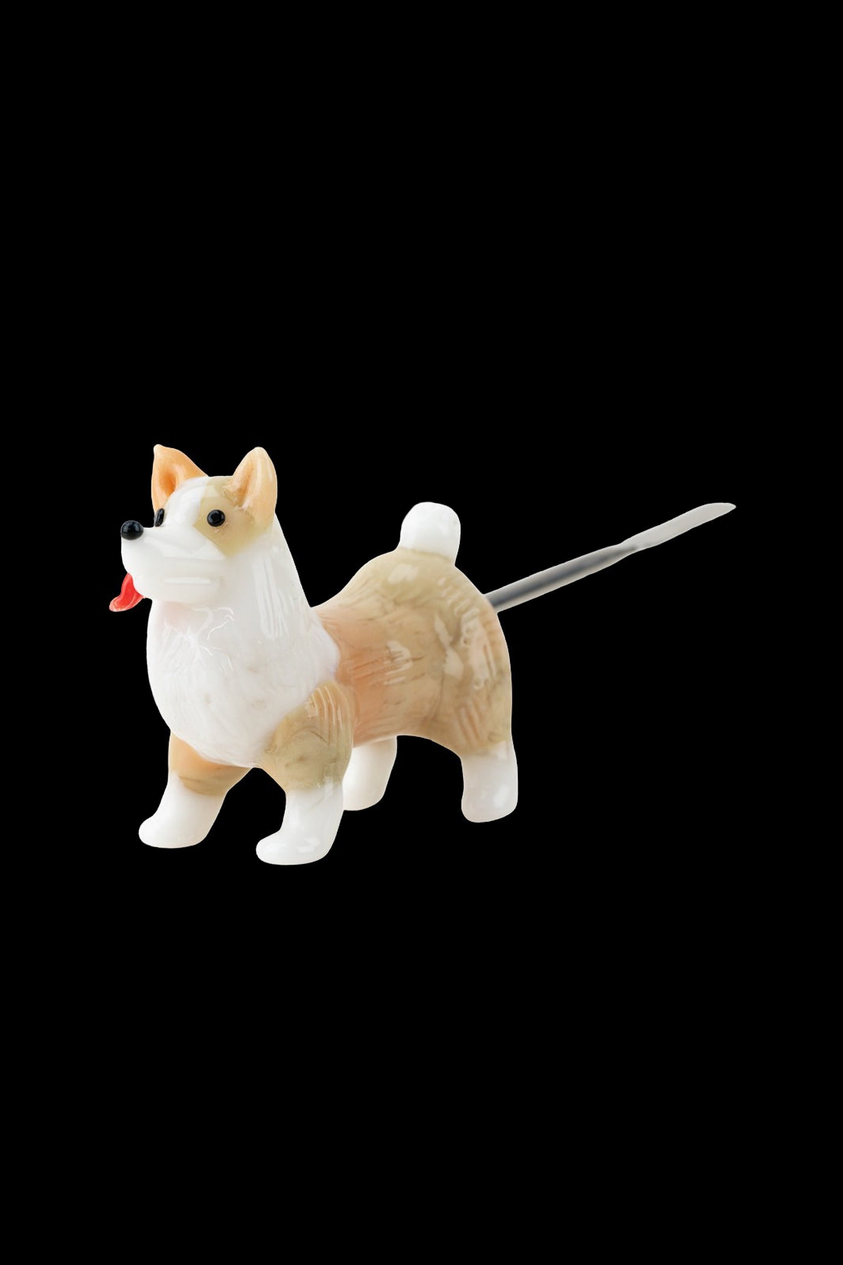 Shiba Inu dog-shaped glass pipe on a black background.