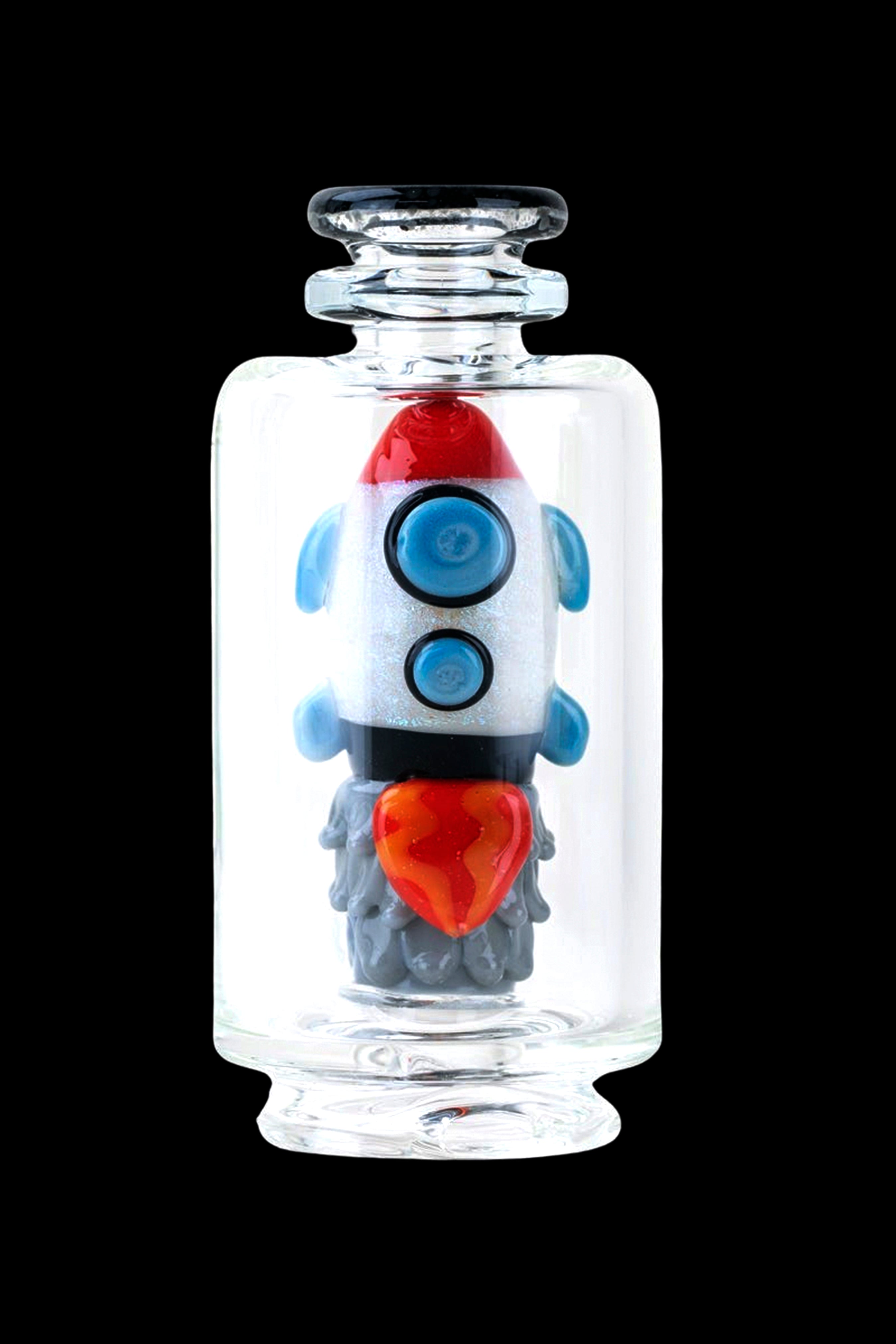 Glass rocket ship-shaped cannabis water pipe inside a clear display jar.