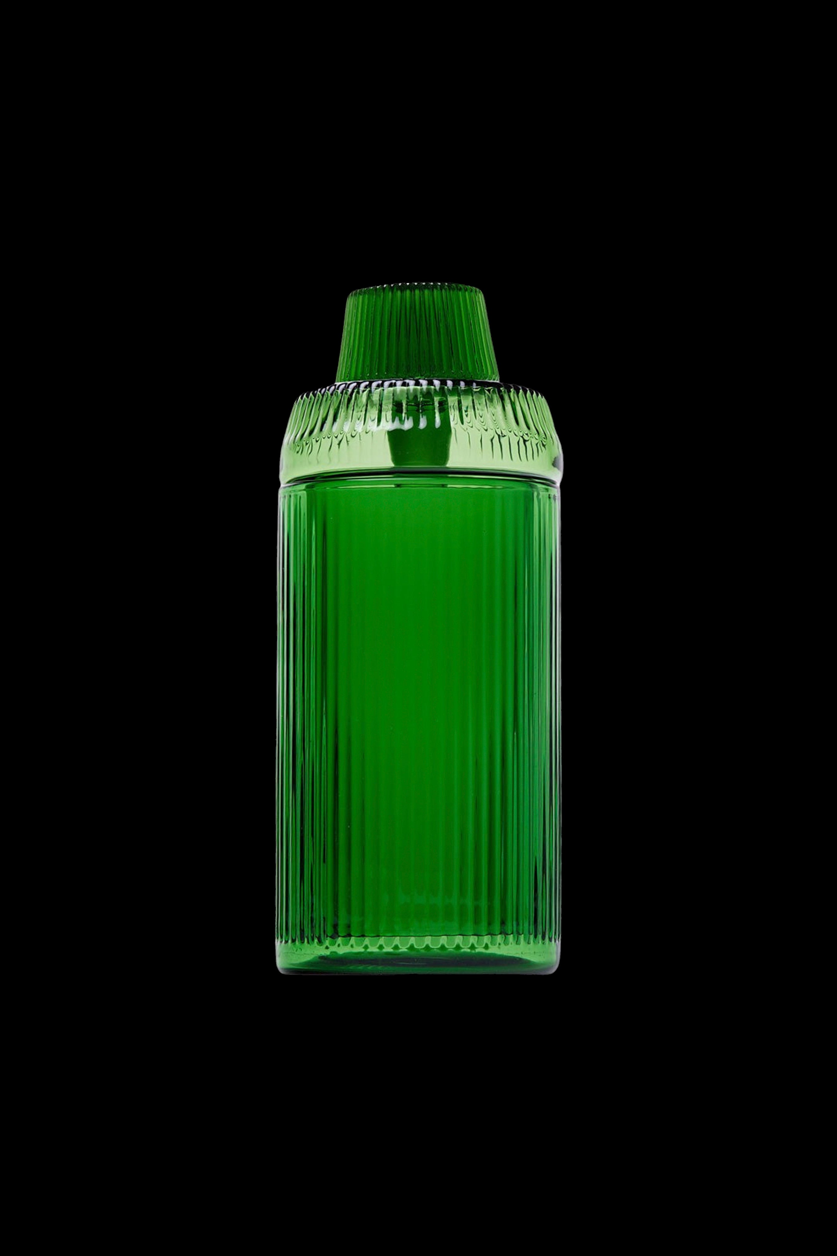 Green glass cannabis oil container on a black background.