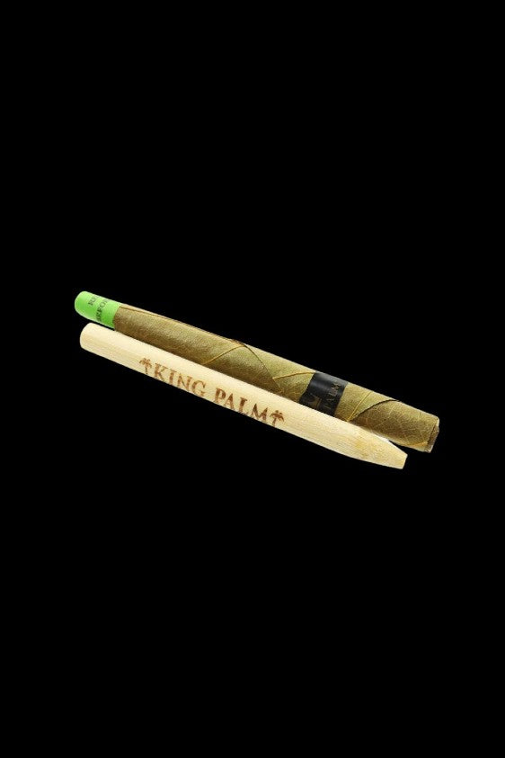 Two rolled palm leaf blunts with ""KING PALM"" printed on one, against a black background."