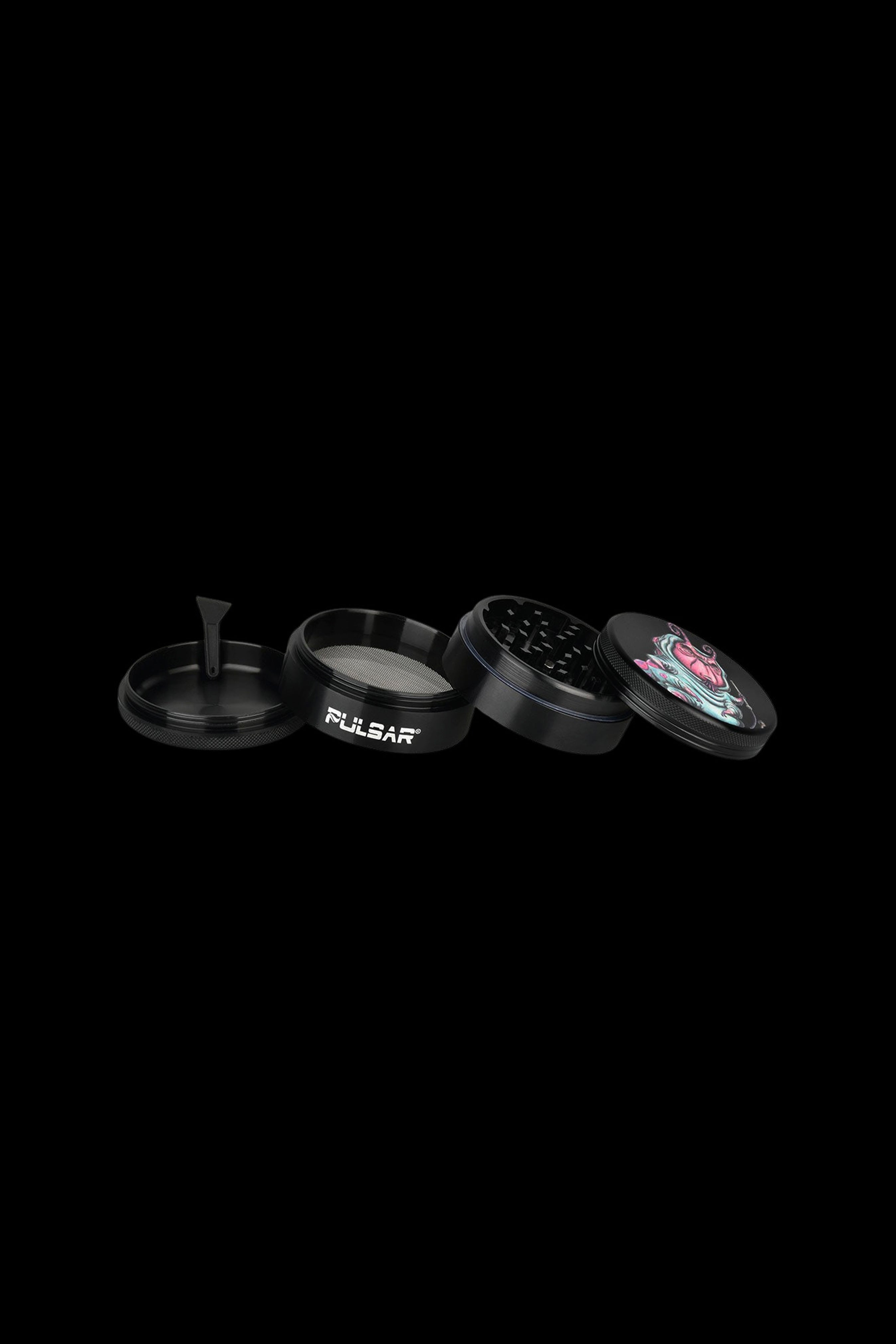 Black metal grinder with four parts, including a floral-patterned top piece.