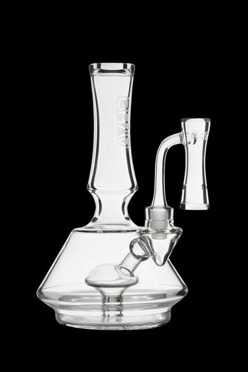 Clear glass water pipe (bong) with a downstem and bowl, isolated on a black background.