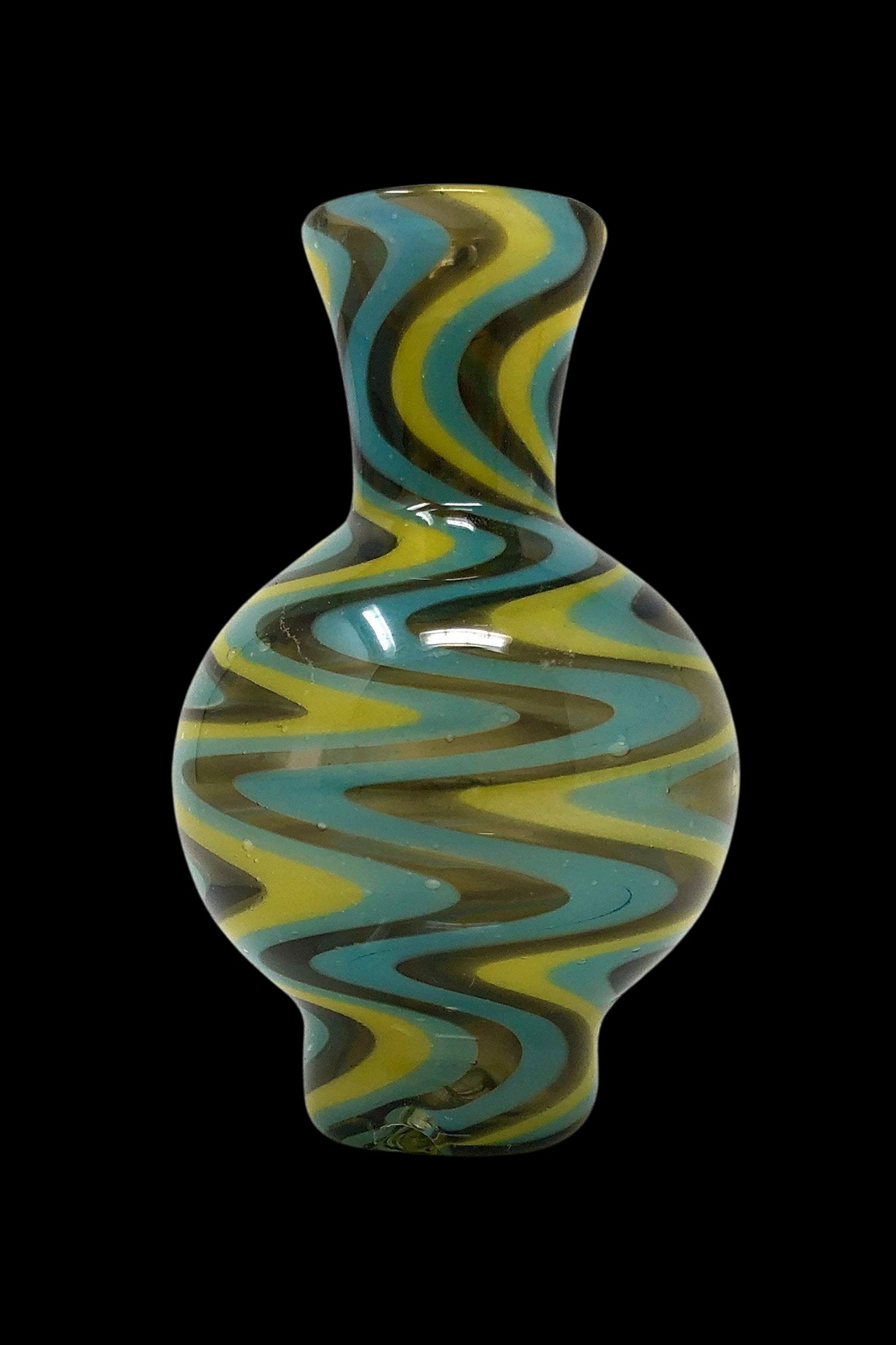 Hand-blown glass water pipe with swirling teal, yellow, and black patterns.