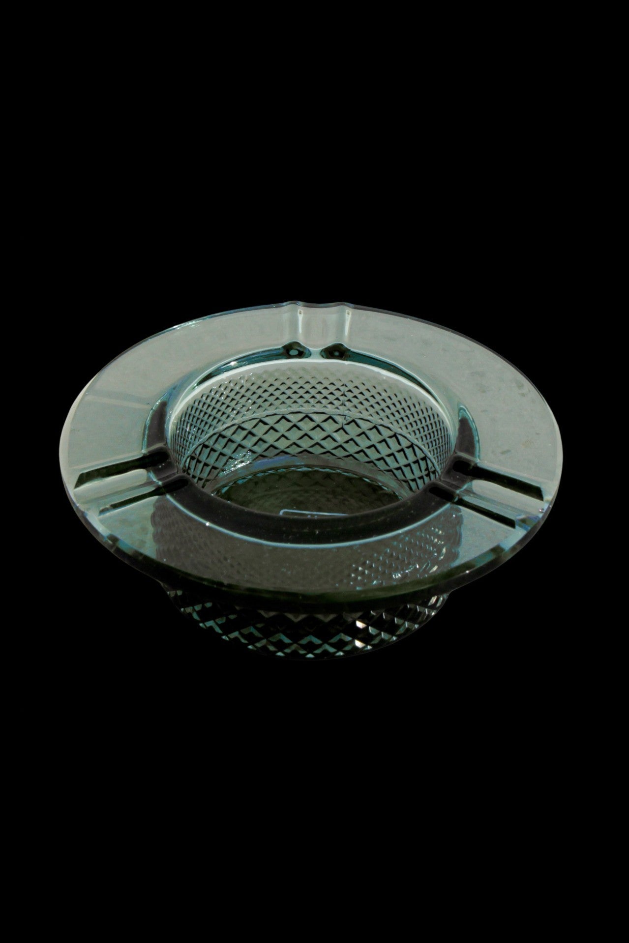 Vintage green glass ashtray with a diamond pattern.