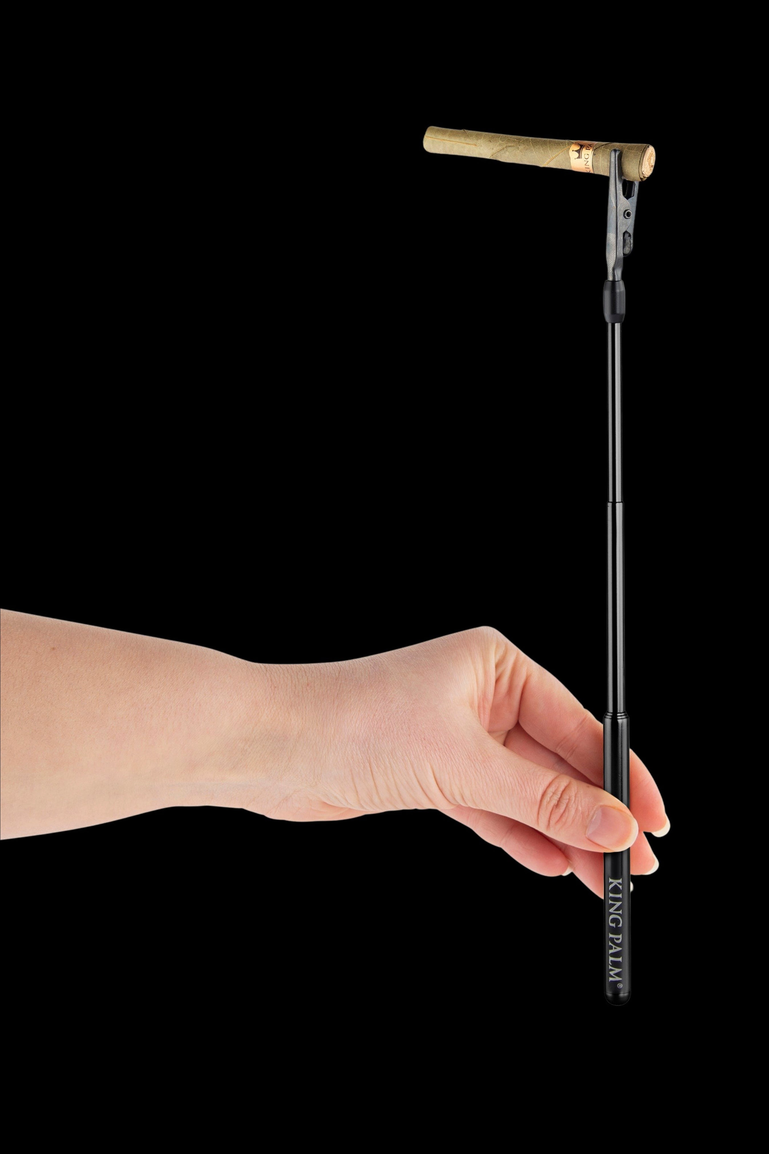 Hand holding a pre-rolled cannabis cigarette with a black filter tip, branded “KING PALM”.