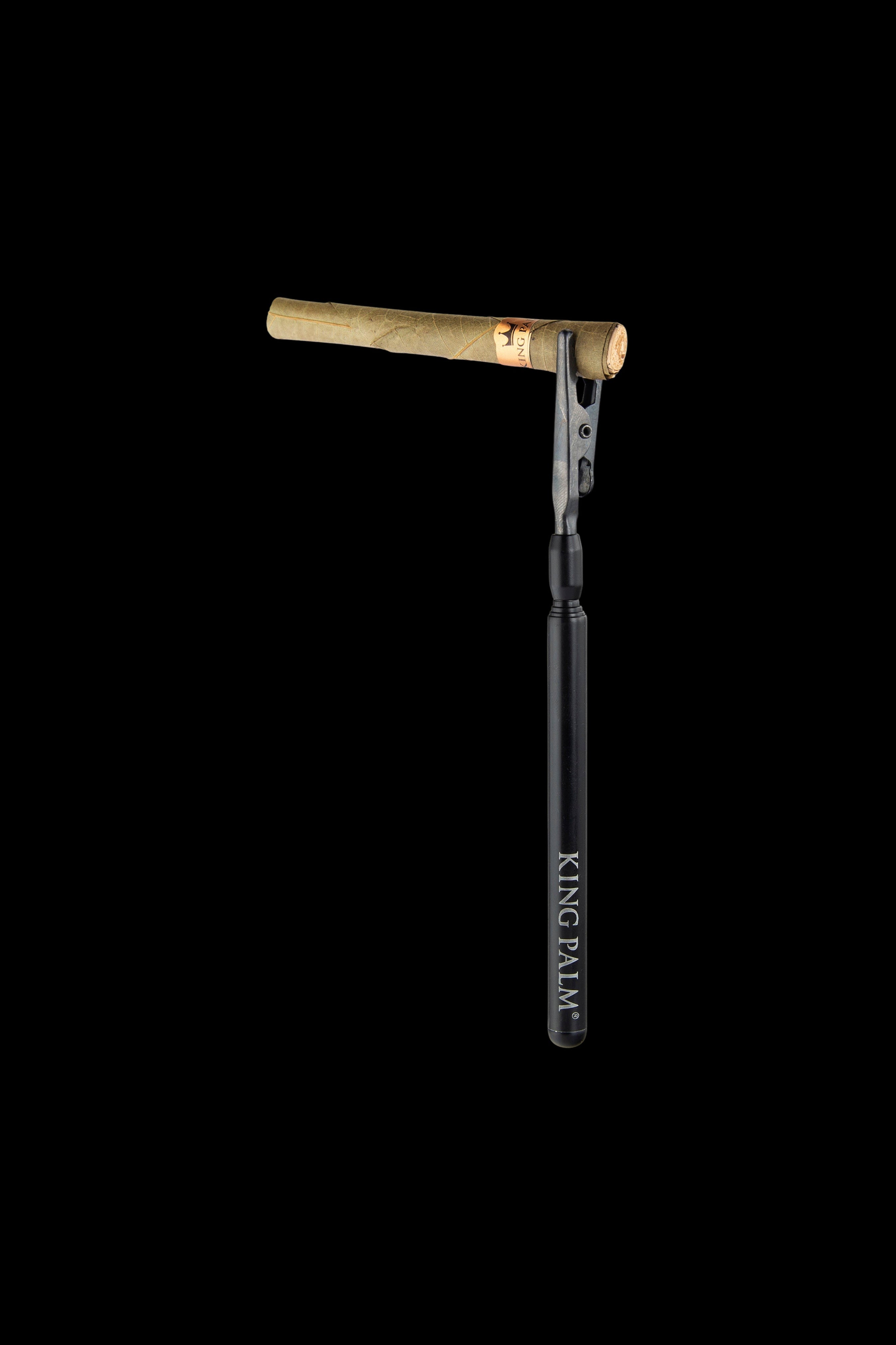 A pre-rolled cannabis blunt with a gold filter tip, displayed against a black background with “KING PALM” vertically printed on the rolling paper.