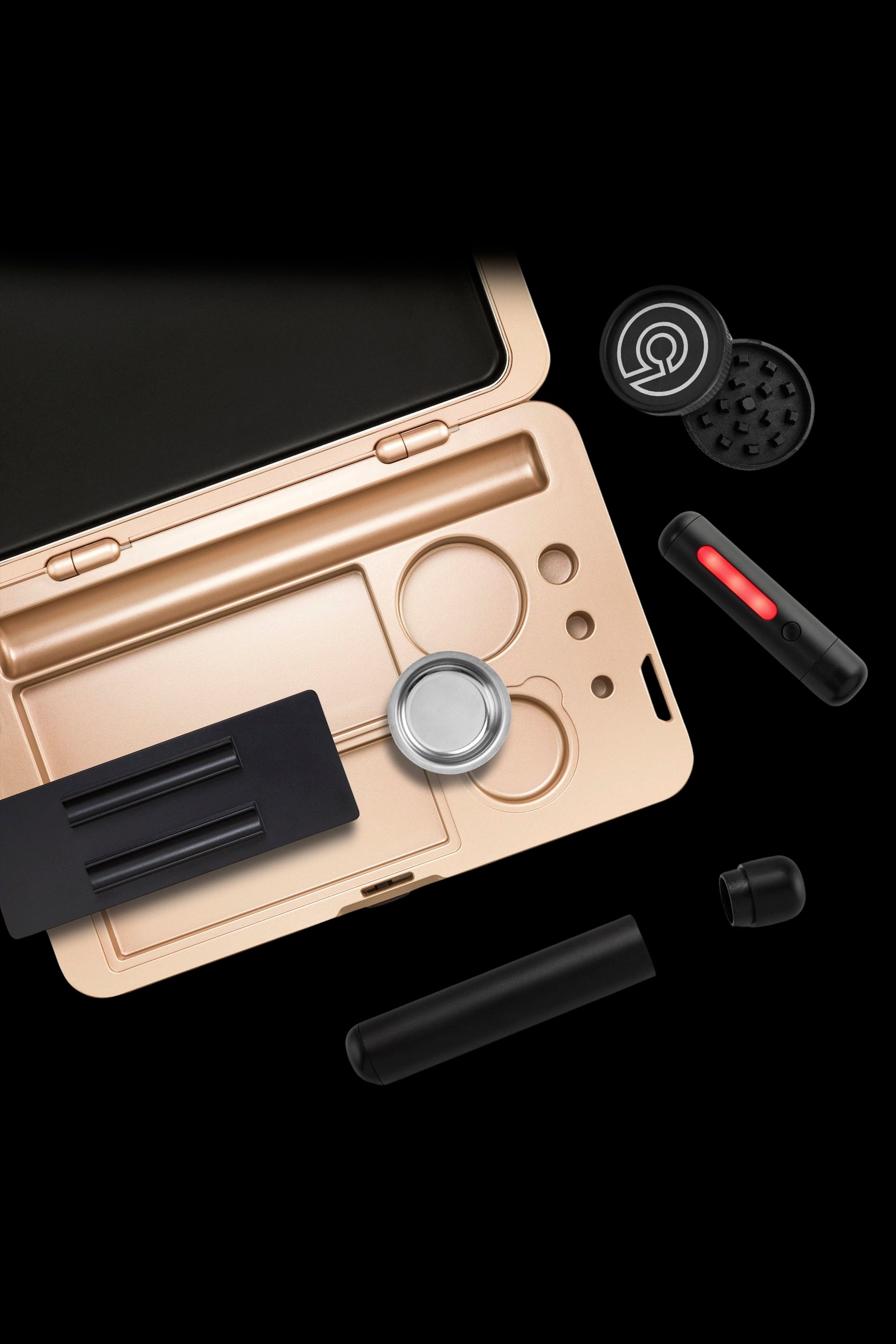 Gold cannabis kit with grinder, storage case, and vaping accessories against a black background.