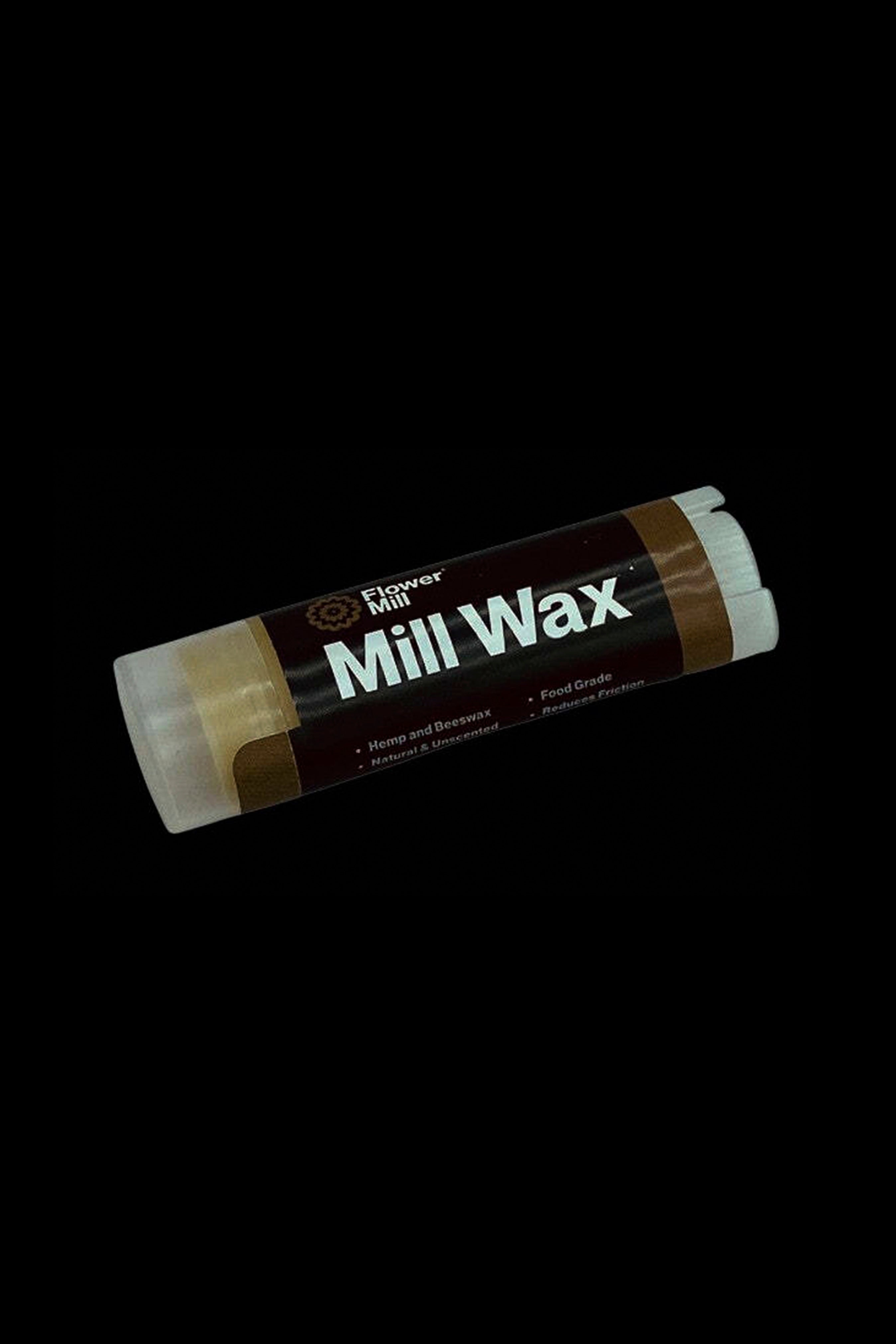 A stick of Flower Mill Wax, a cannabis accessory for reducing friction, against a black background.