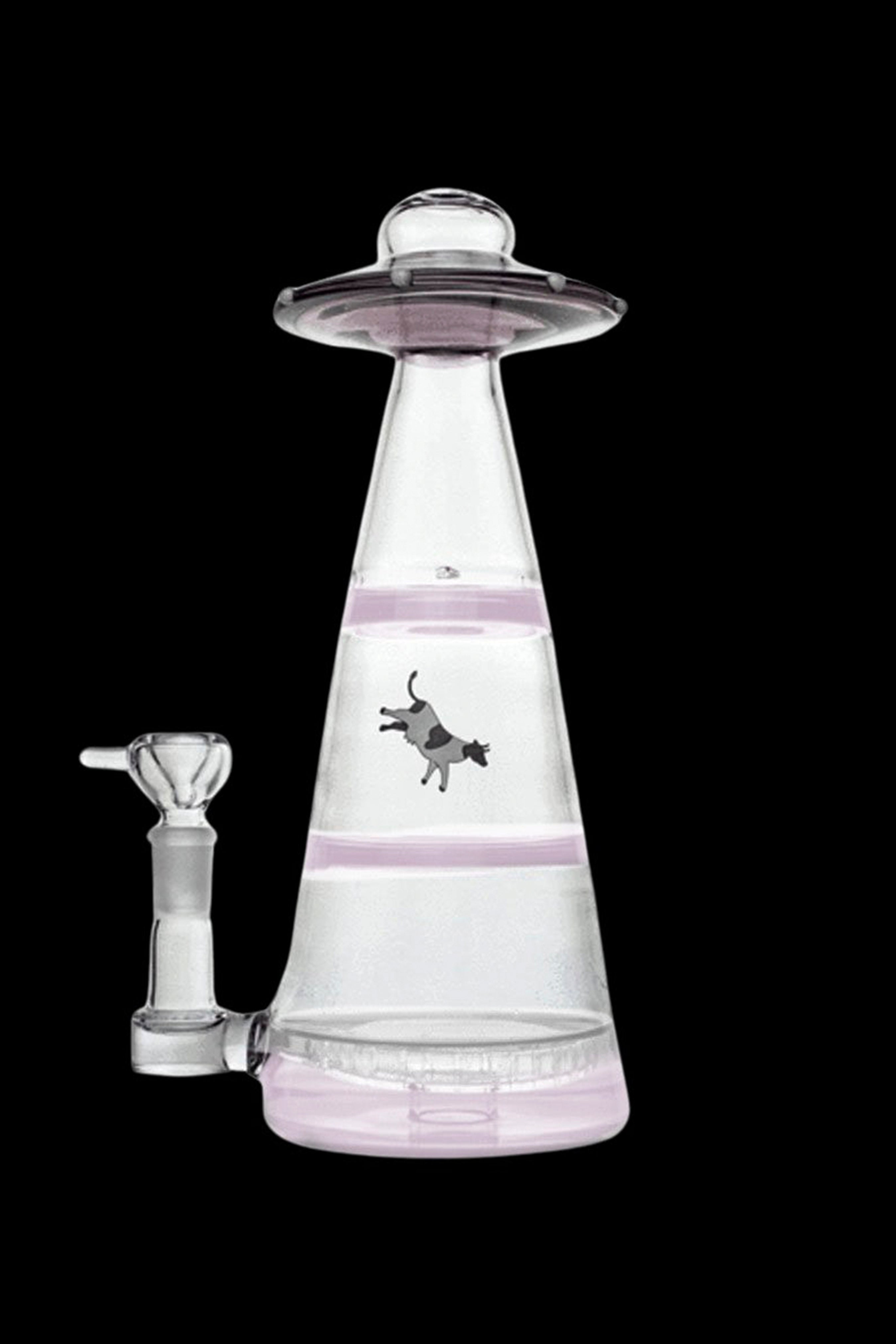 Pink glass water pipe shaped like a UFO with a cow illustration.