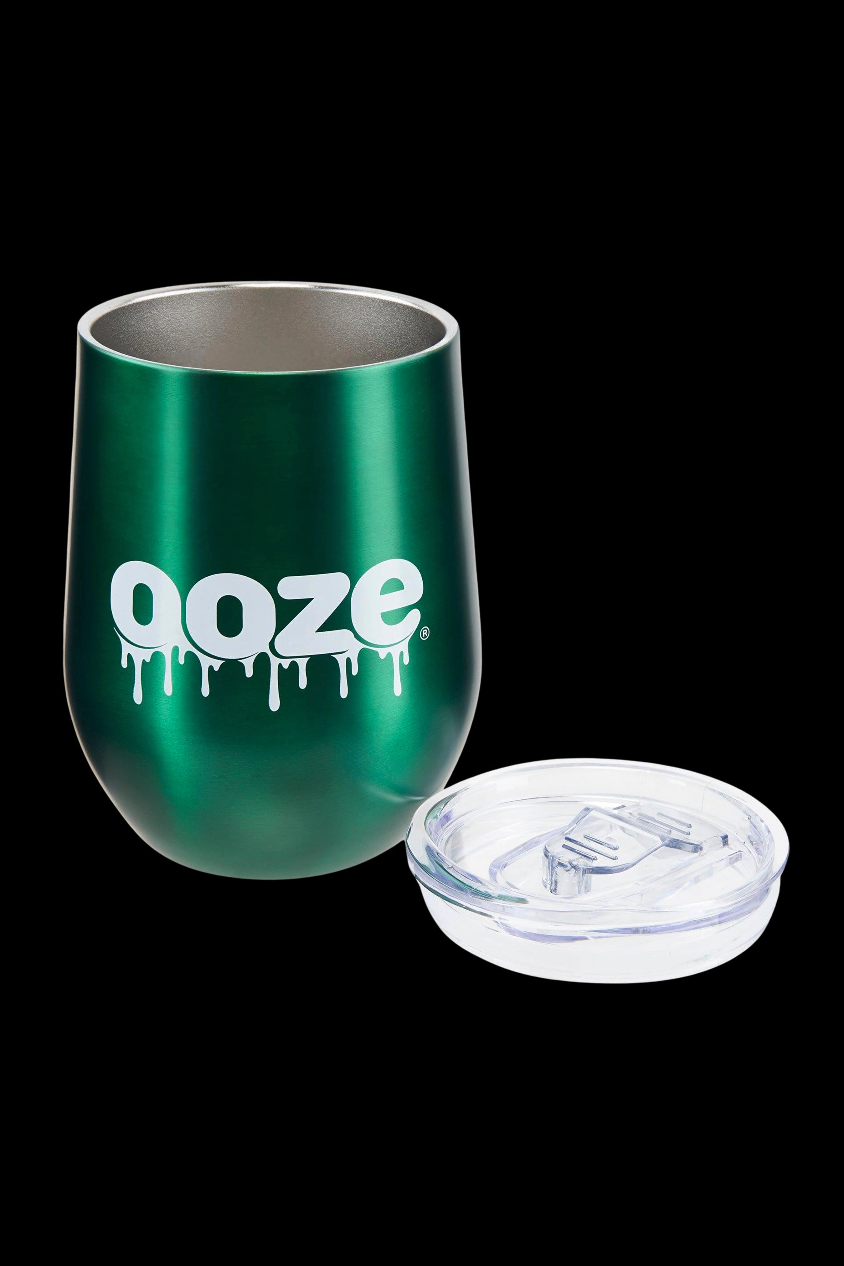 Dark green cannabis accessory cup with “ooze.” logo and clear lid.