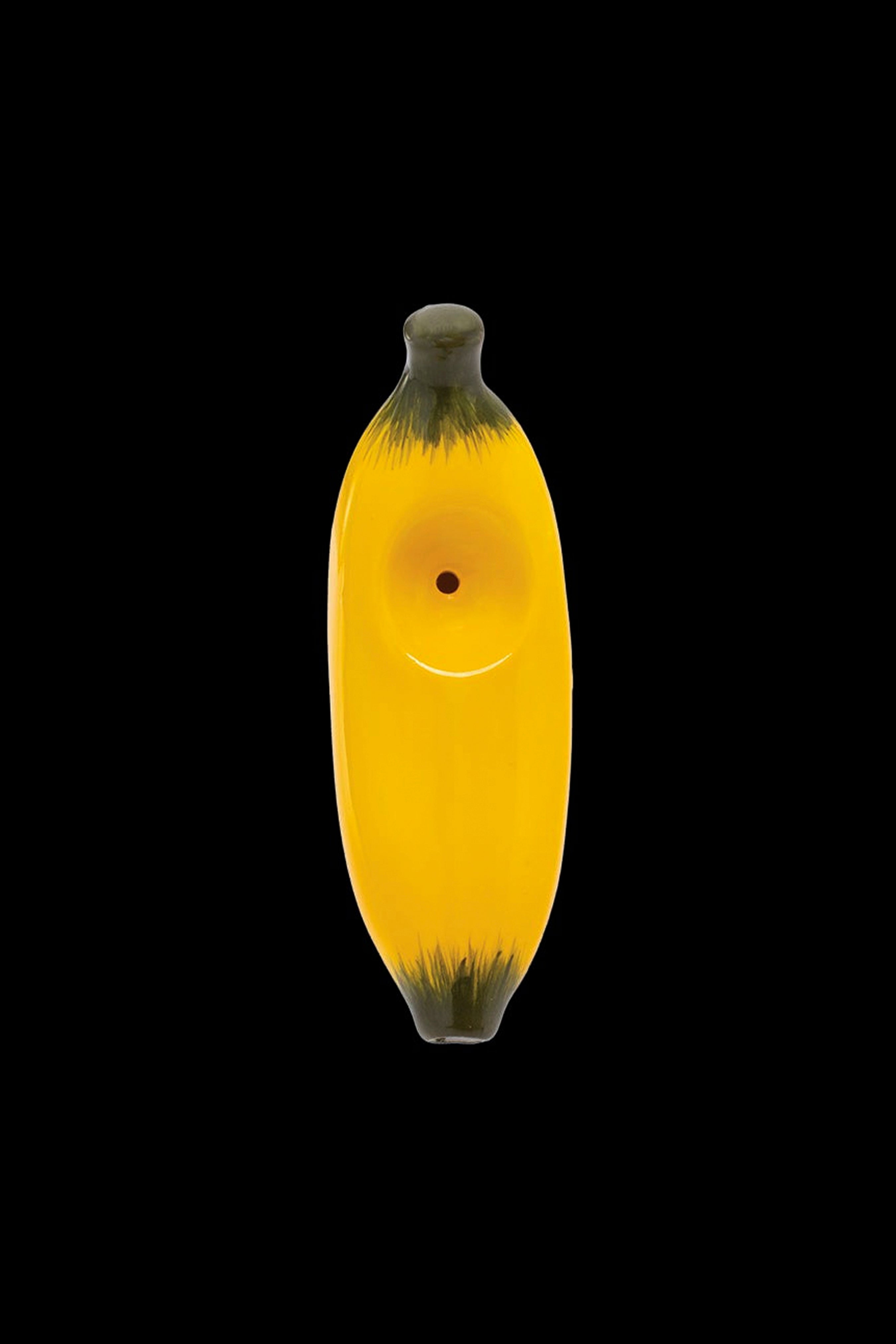 Yellow glass banana-shaped smoking pipe with a smiling face on a black background.