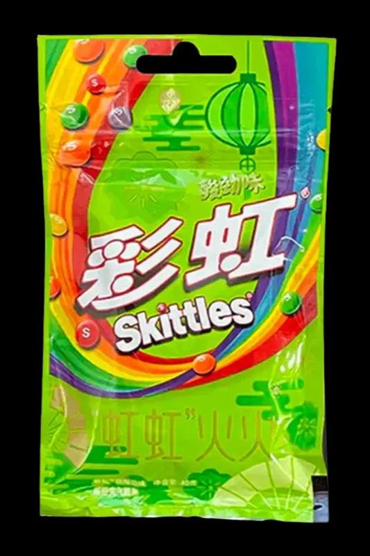 A colorful, resealable bag labeled “Skittles” in English and Chinese characters, positioned near a cannabis accessory.