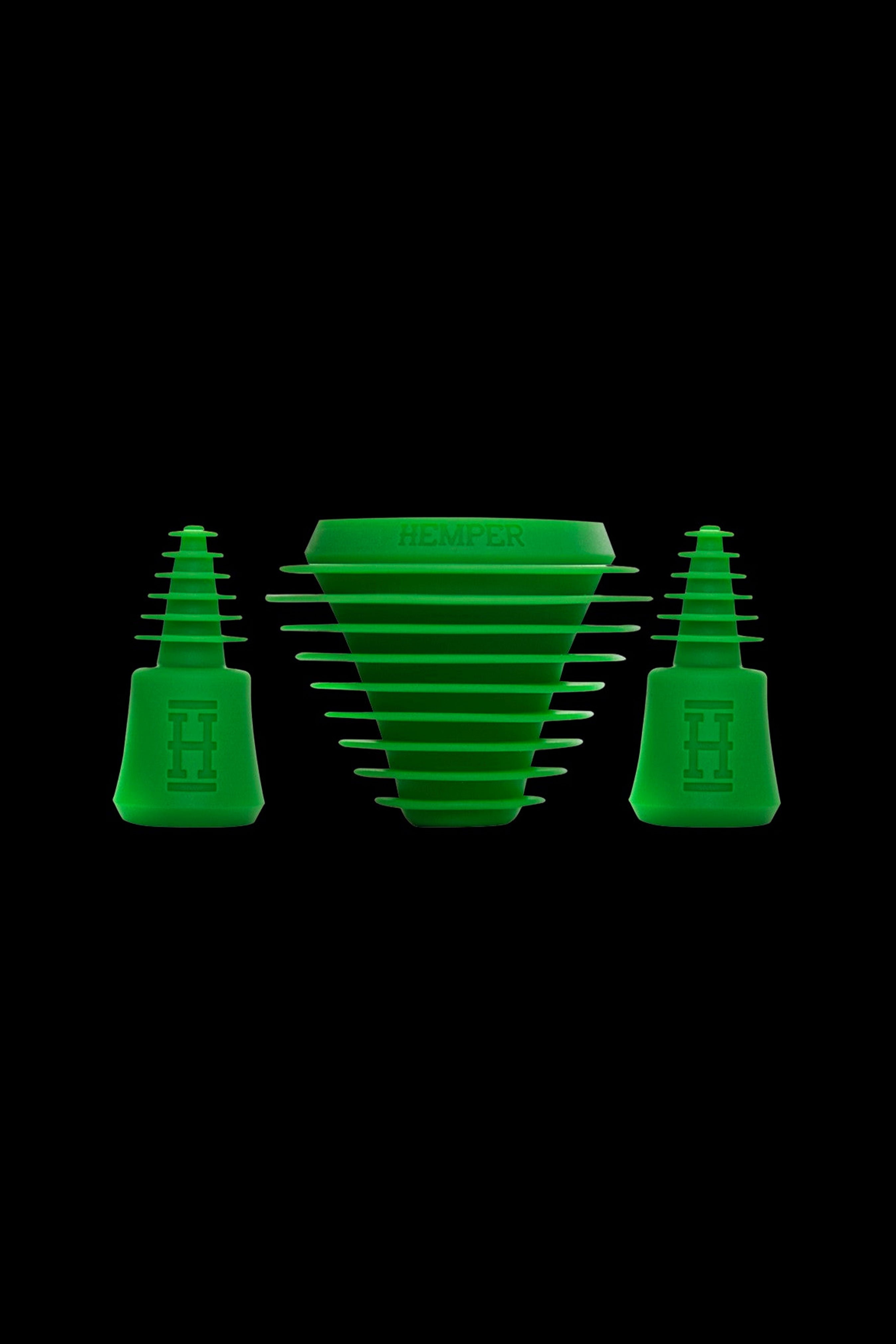 Green silicone hash rosin press pucks and collection funnel isolated on a black background.