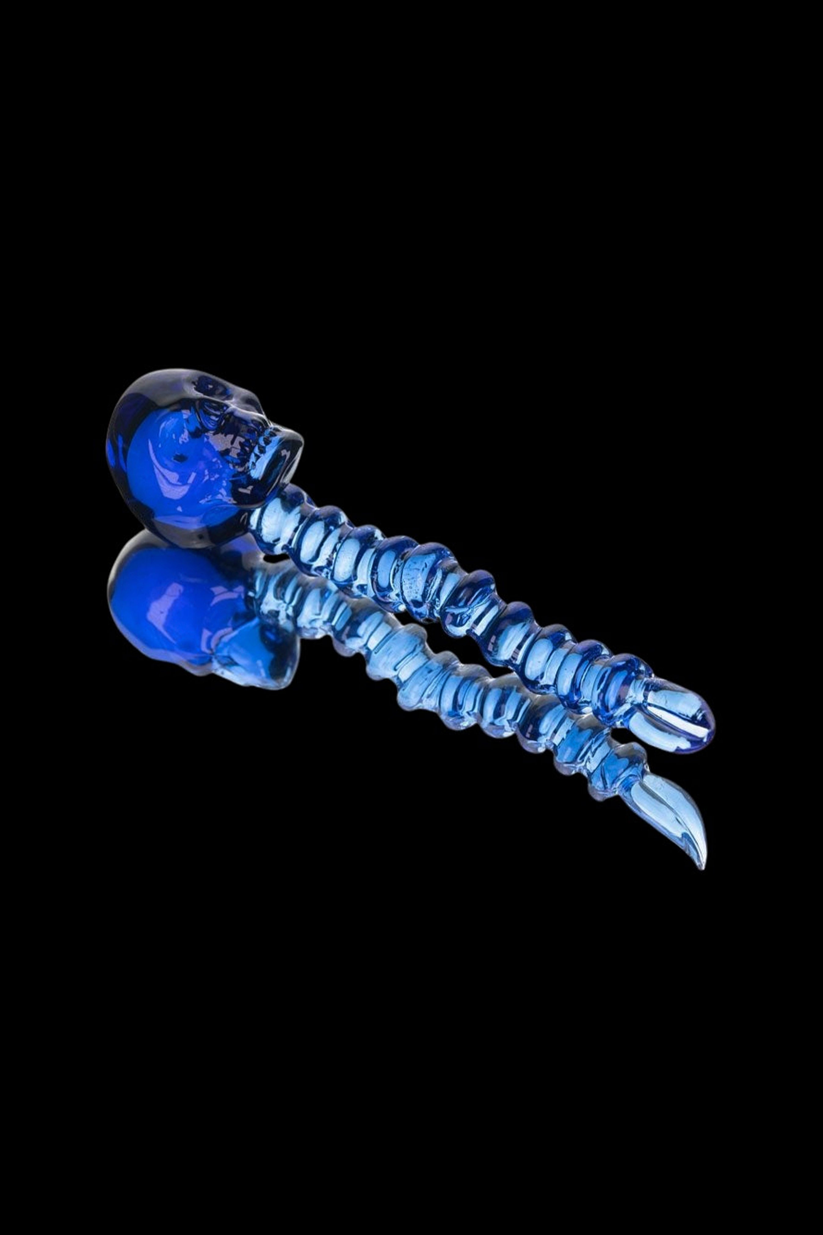 Blue glass cannabis oil burner pipe shaped like a spine with skull ends.