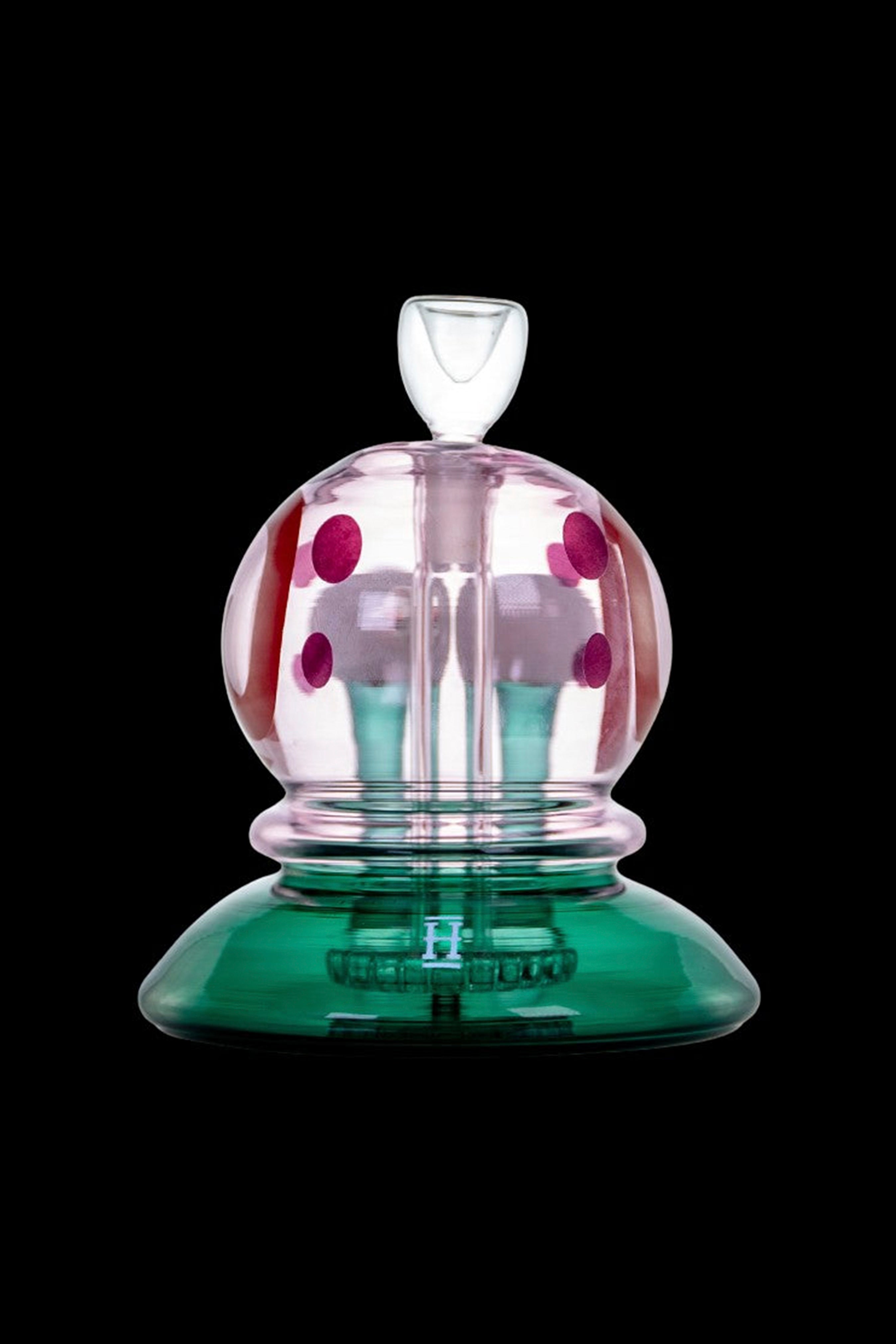 Hand-blown glass bubbler with pink polka dots and a green base.