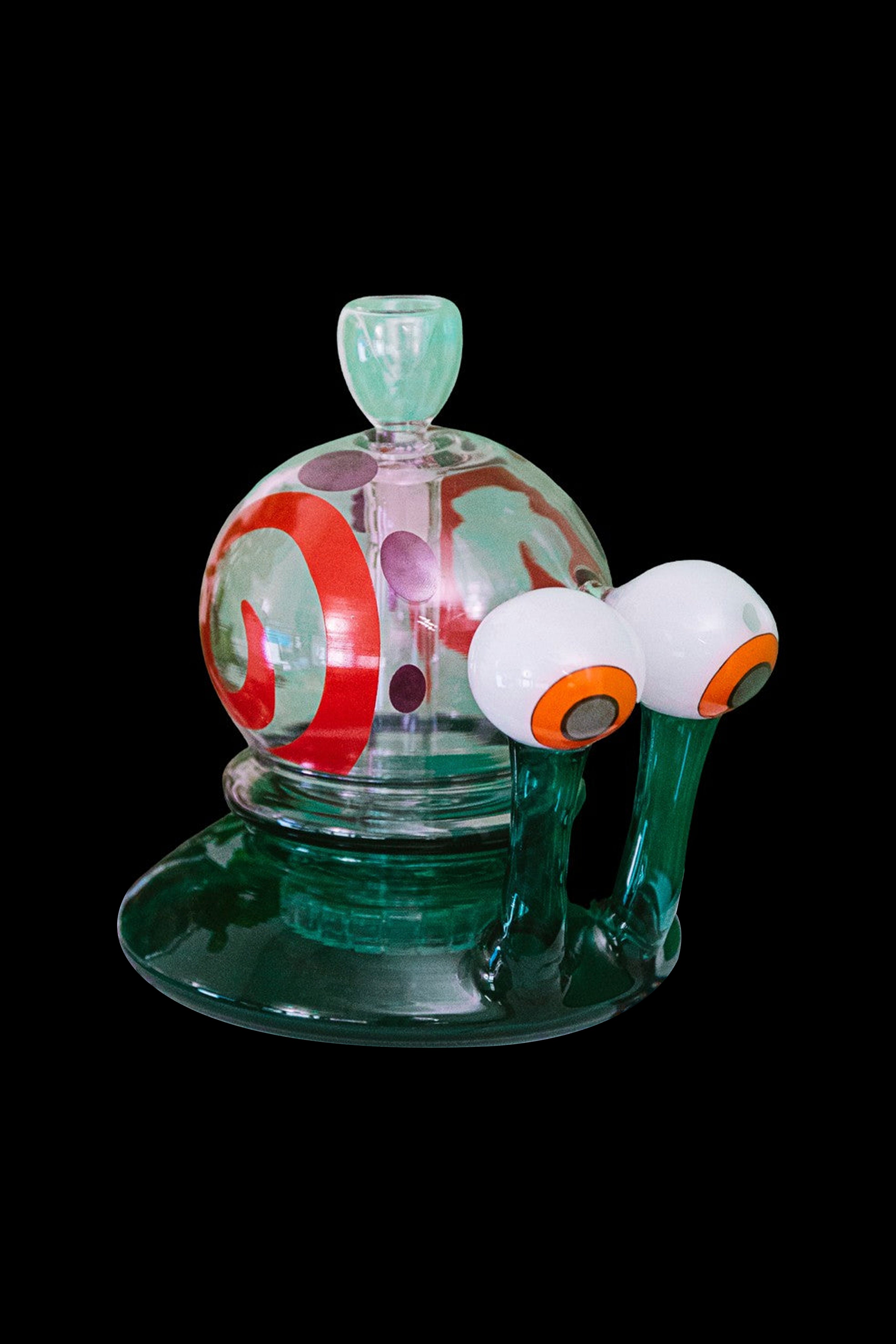 Hand-blown glass rig with an eye-shaped perc, featuring swirling green and red patterns on a dark background.