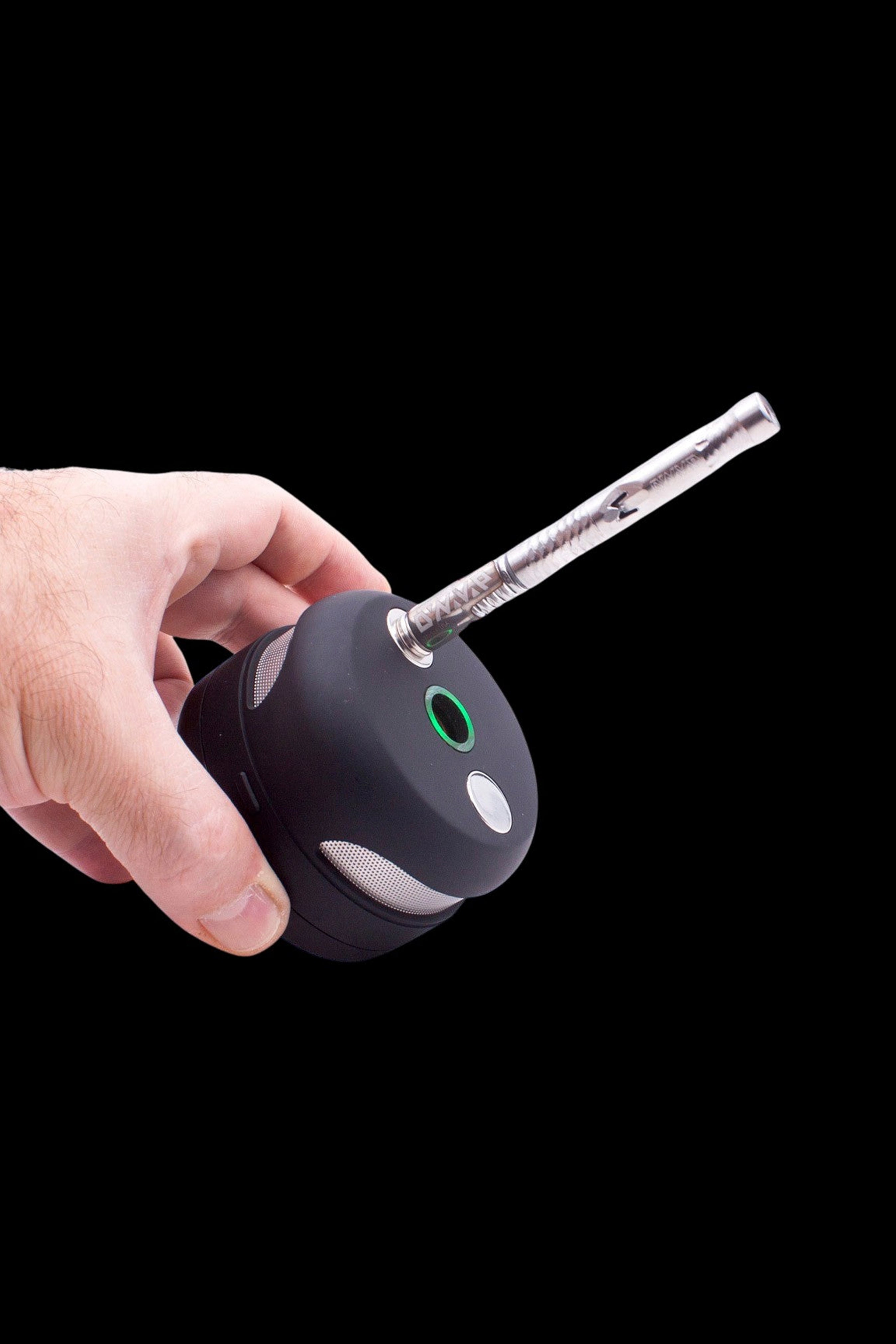 Hand holding a black cannabis vaporizer with a glass mouthpiece.
