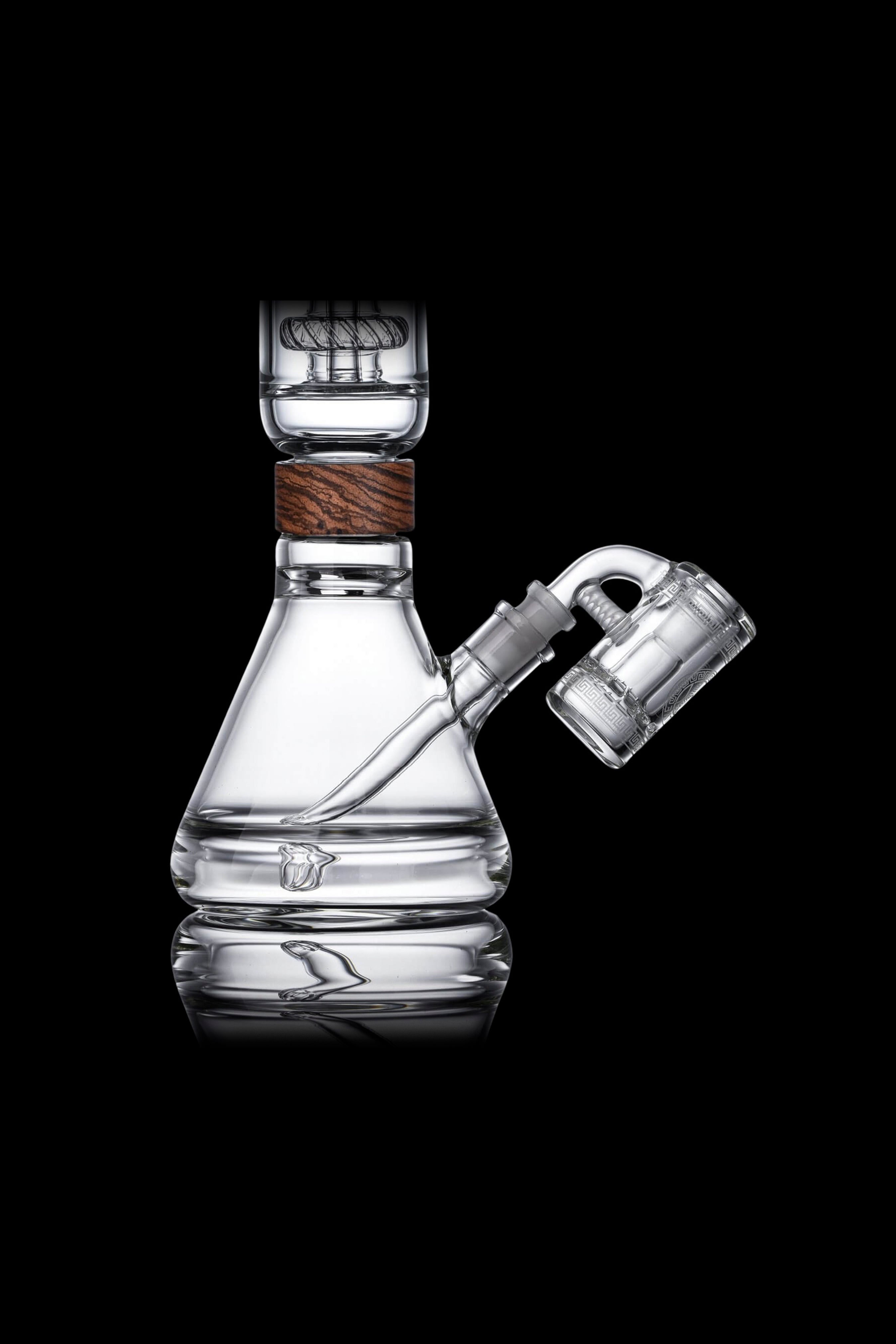 Clear glass water pipe (bong) with wooden accent and connected glass bubbler, displayed on a reflective surface against a black background.