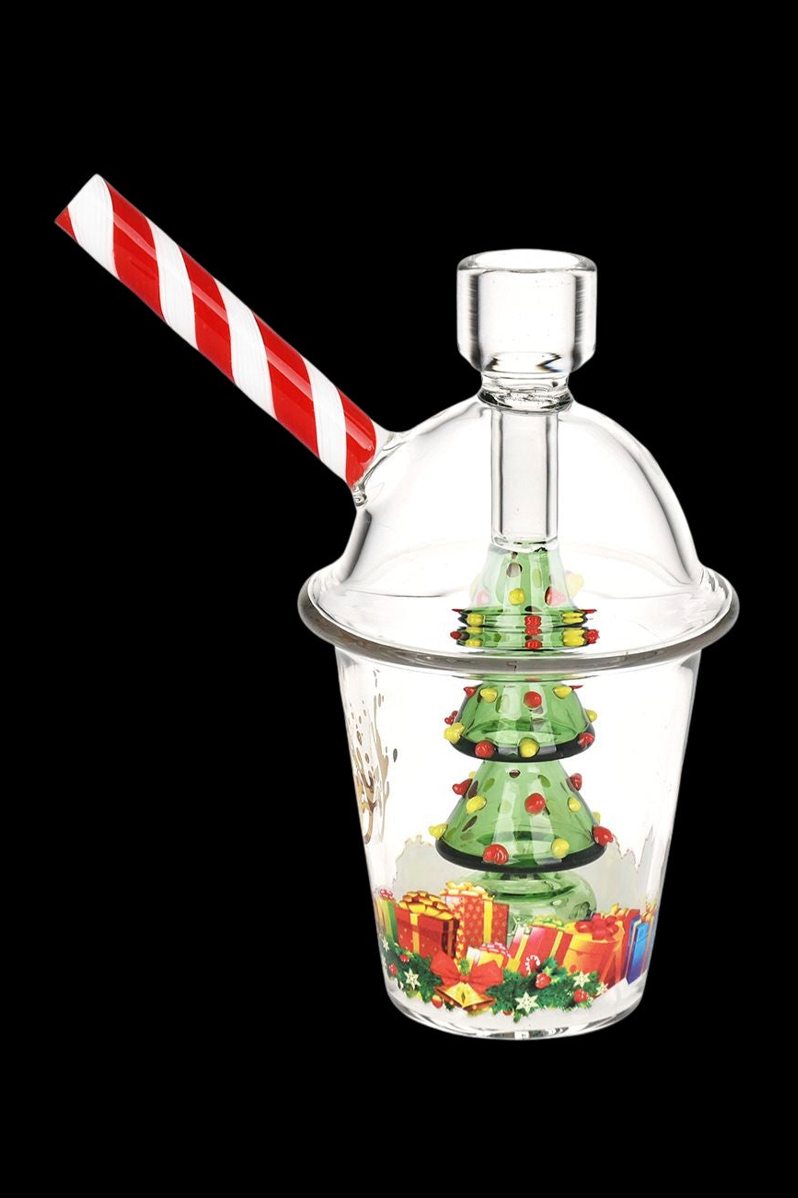 A glass bubbler shaped like a Christmas-themed snow globe with a candy cane straw.