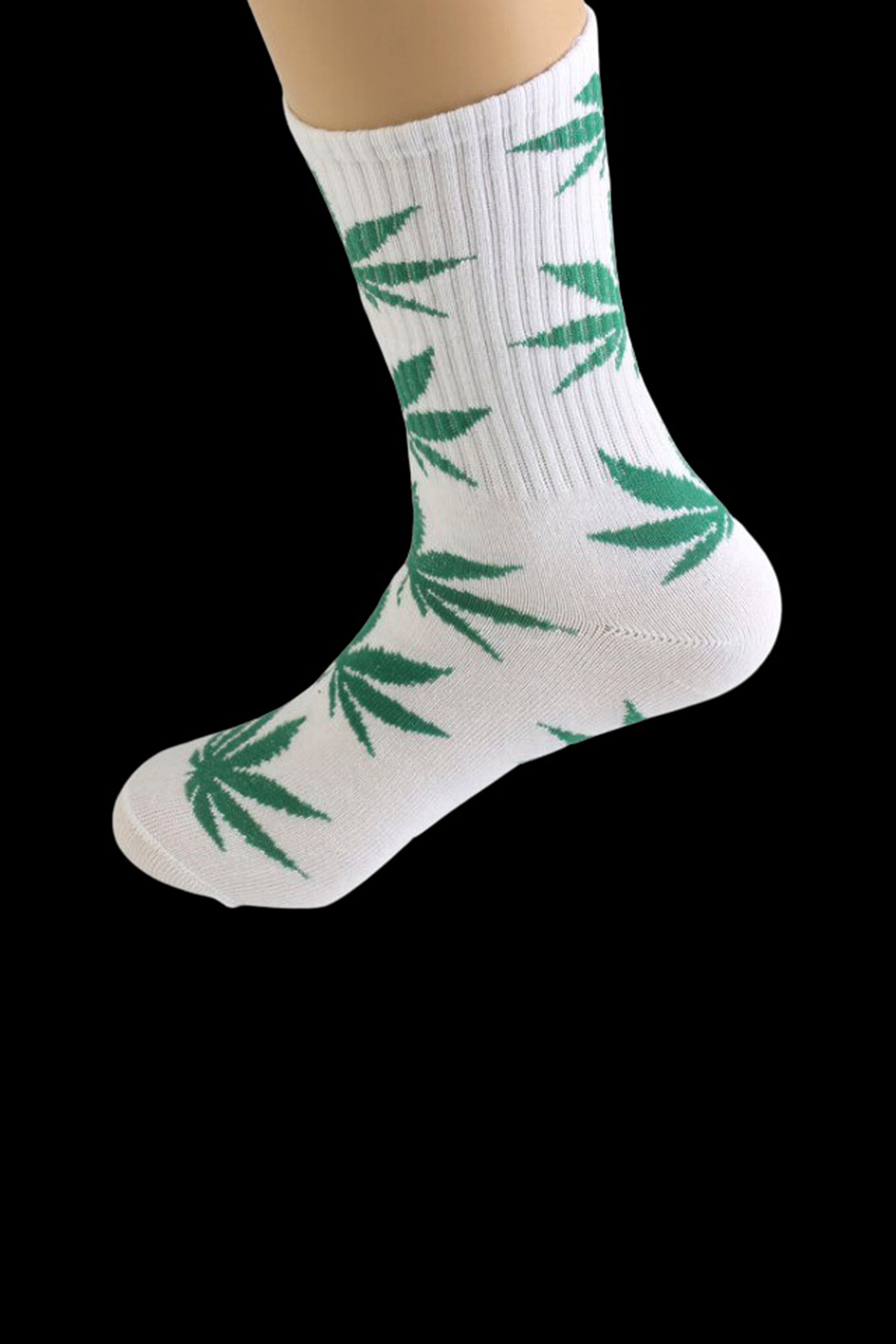 White crew socks with repeating green cannabis leaf pattern.