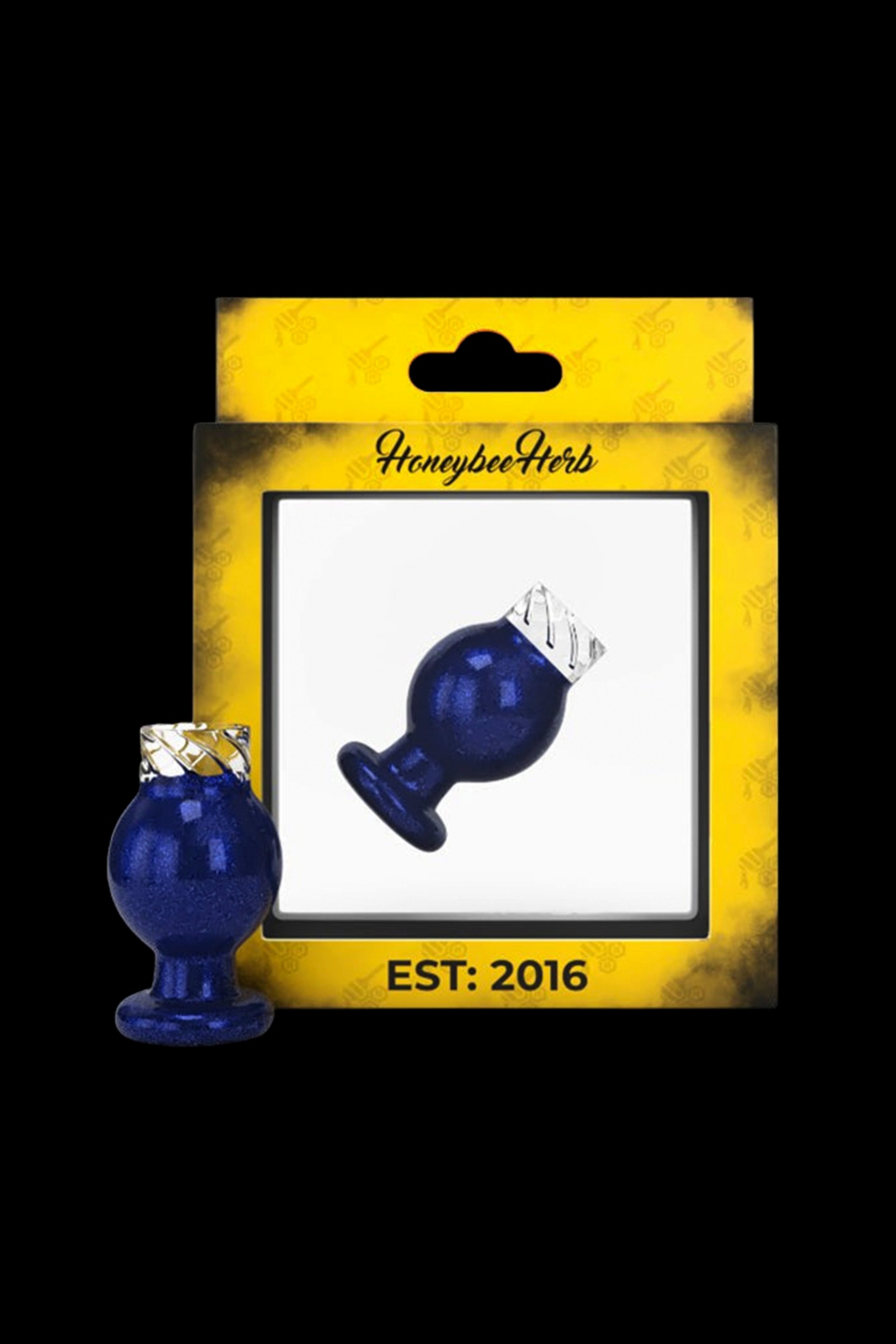 Blue glass cannabis water pipe in packaging labeled “Honeybee Herbs EST. 2016”.