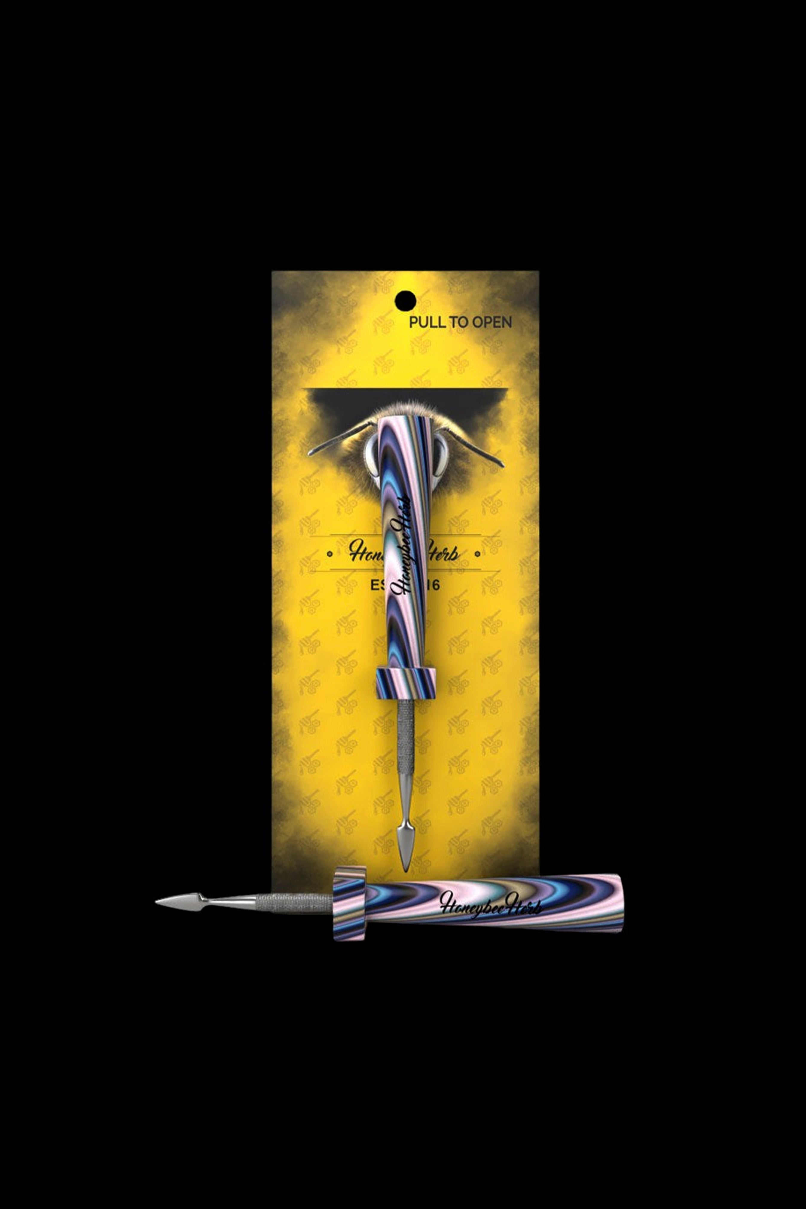 A gold and black box displaying a sleek, iridescent cannabis dab tool with a bee-themed design.