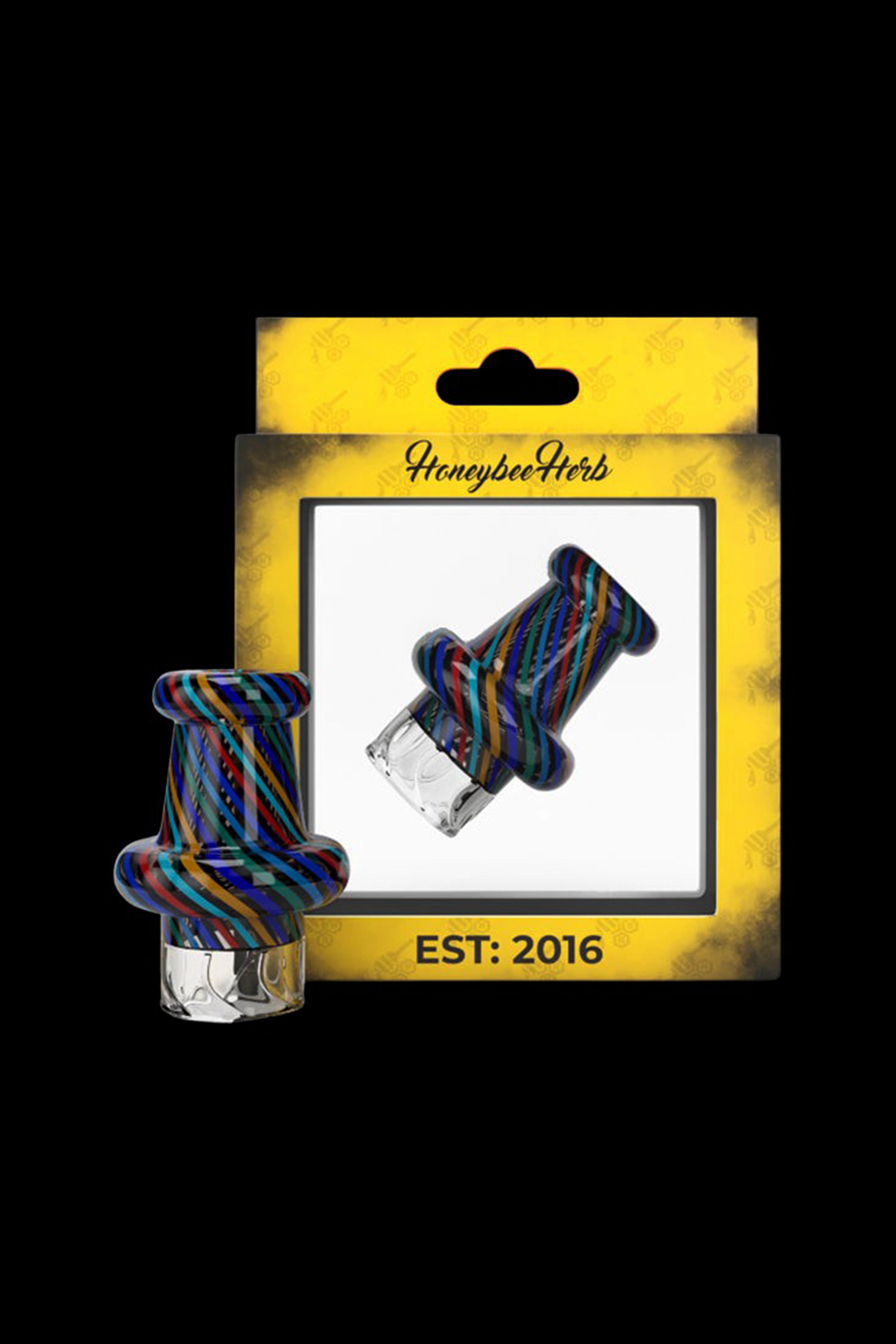 Colorful glass oil rig attachment packaged on a white and yellow card labeled "Honeybee Herb EST: 2016".