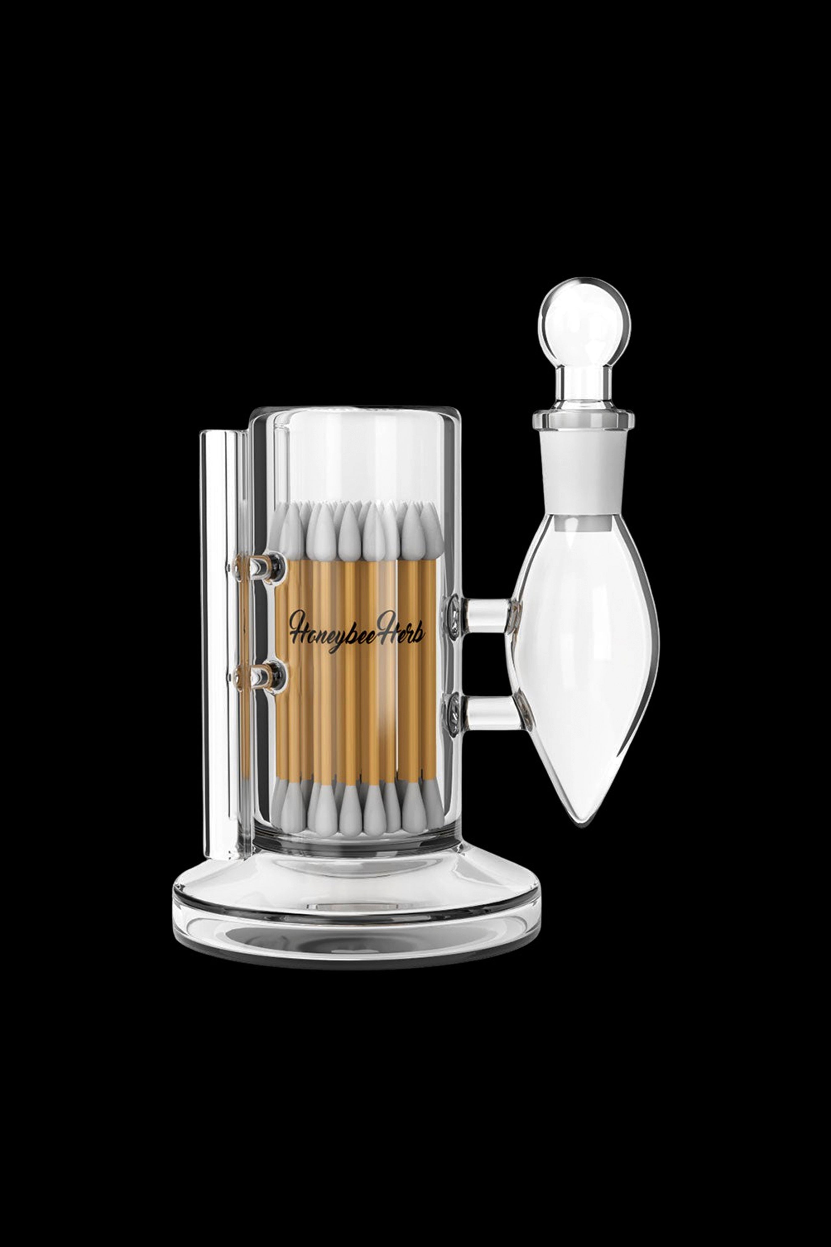Clear glass cannabis grinder with a detachable collection chamber, branded “Honeybee Herb.”
