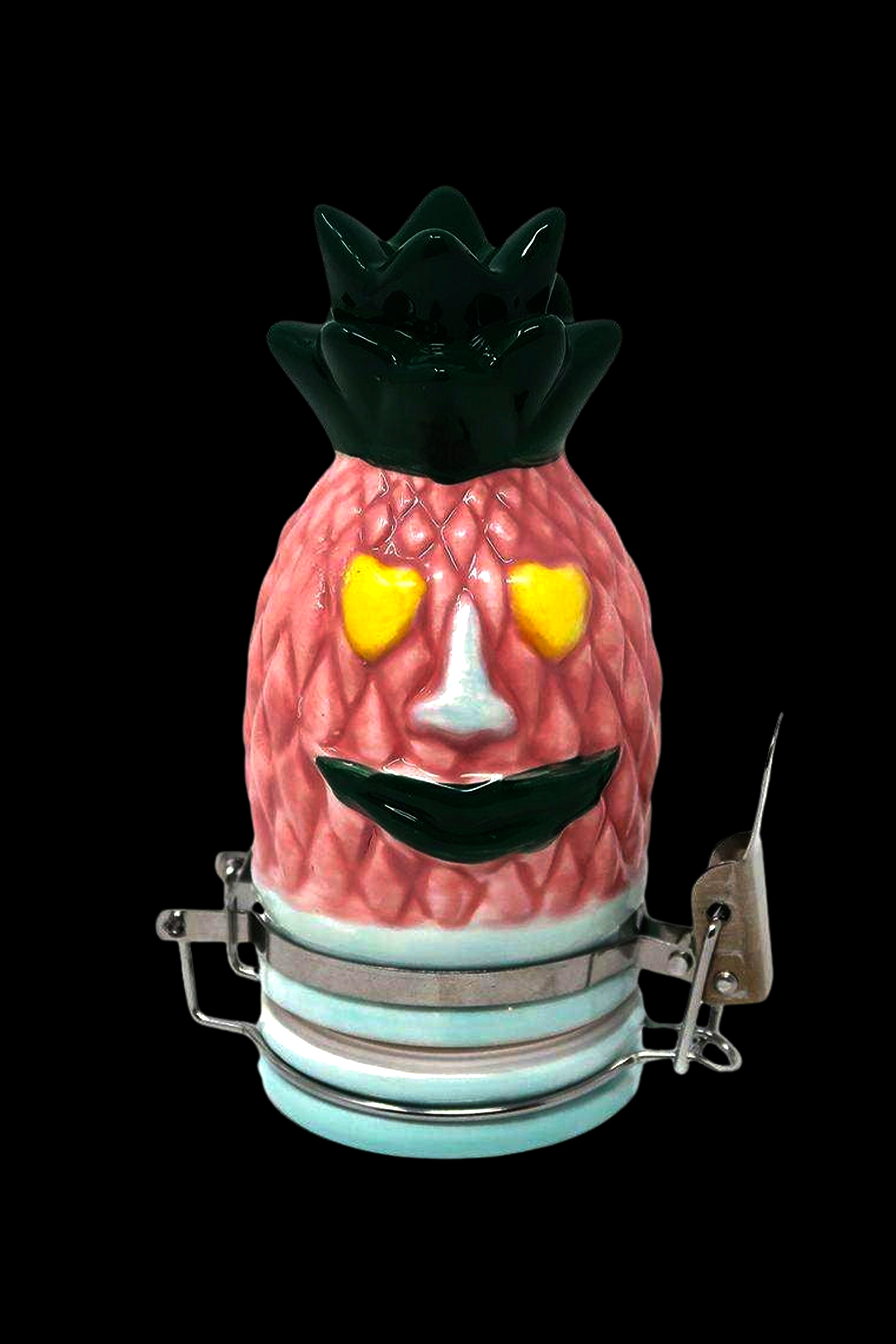 A ceramic pineapple-shaped container with a smiling face and glowing eyes, secured with metal clamps, likely used as a storage jar for cannabis.