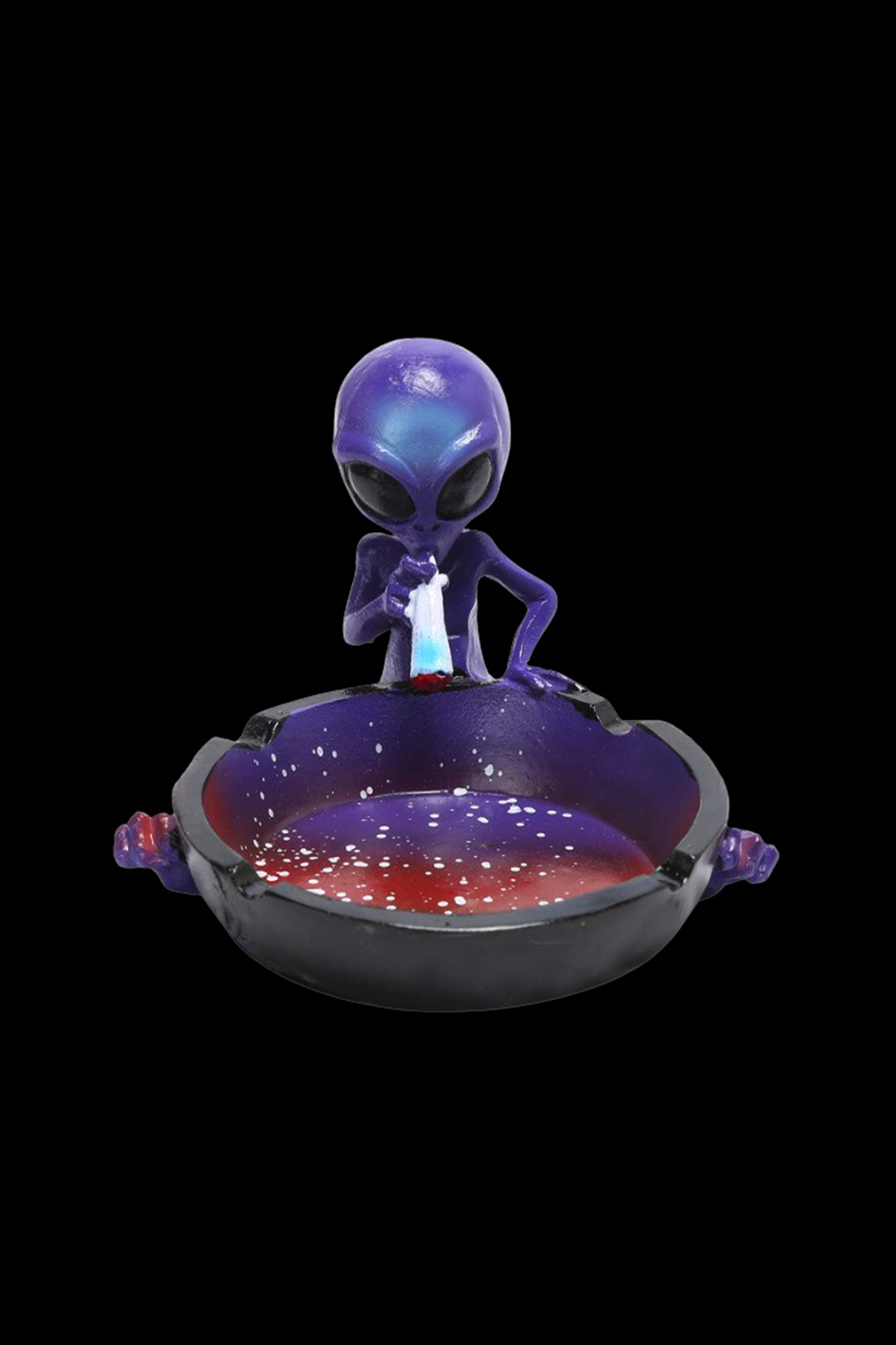 Purple alien figurine seated within a speckled ashtray, likely for cannabis use.