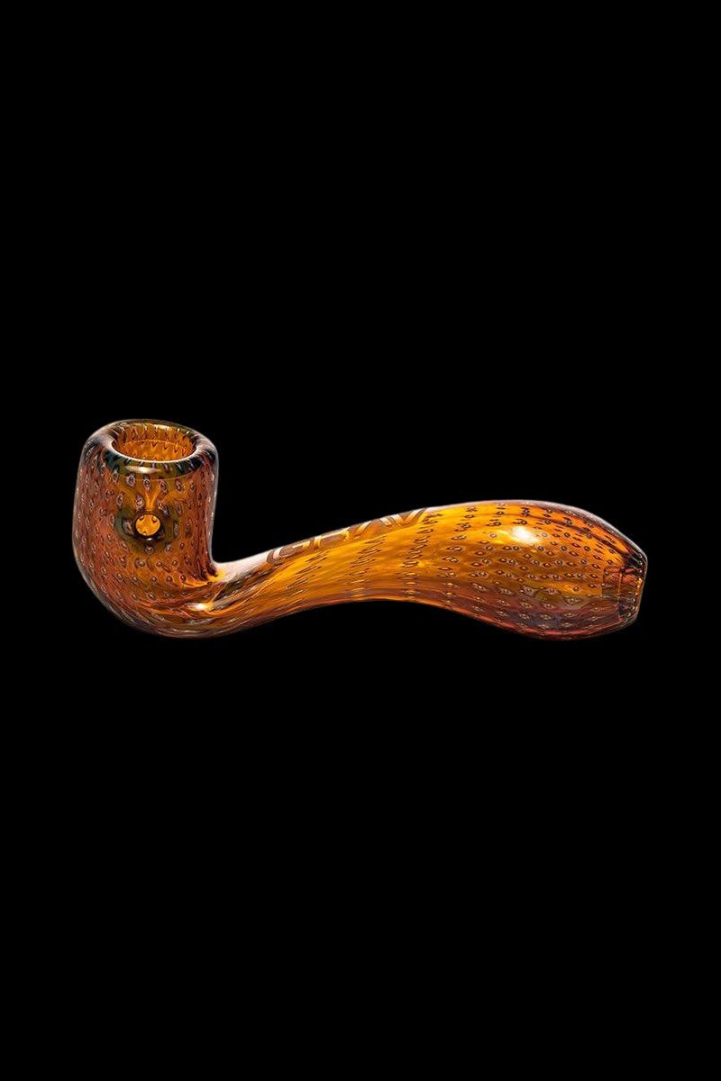 Ornate orange glass pipe against a black background.
