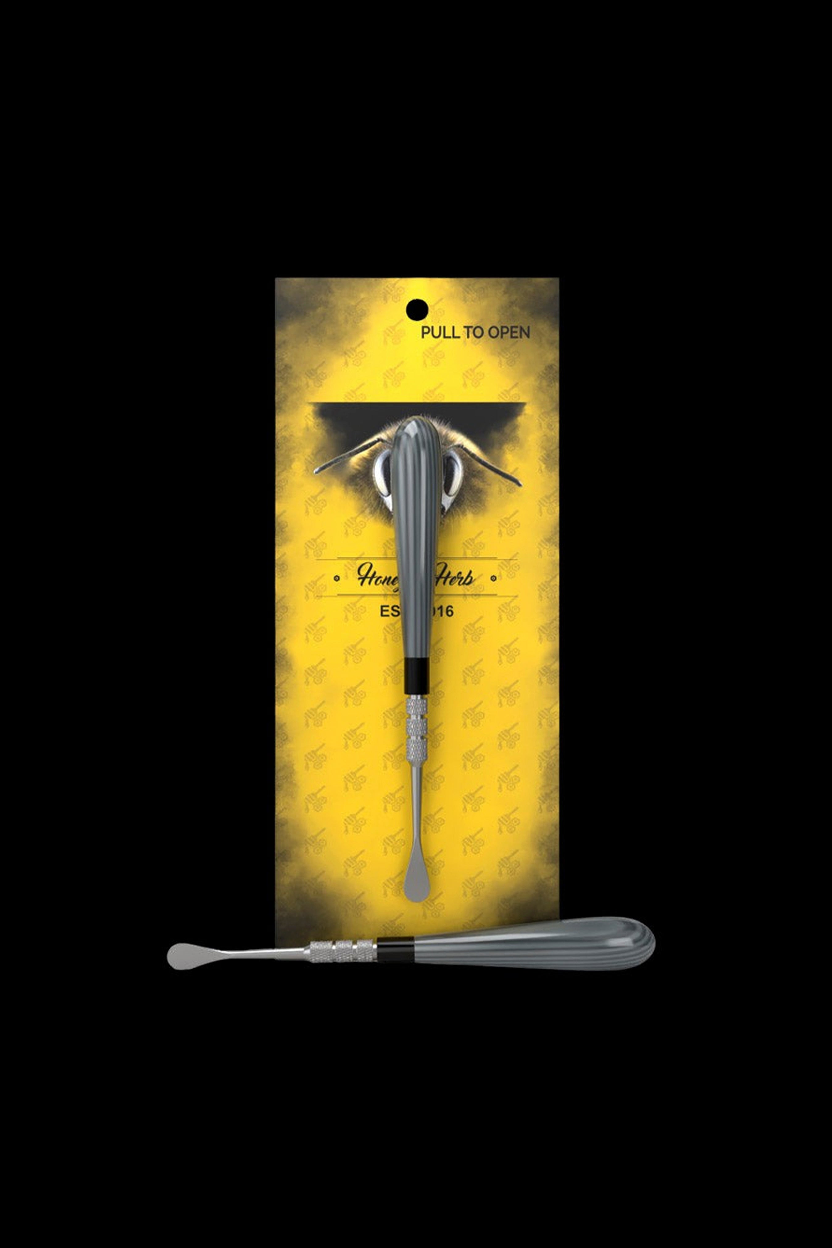 Top-down view of the Gray Honeybee Herb Classic Dab Tool centered on its yellow branded card with a bee graphic and black background