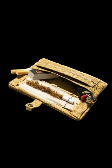 Gold cannabis kit with rolling papers, a grinder, and a lighter inside an open pouch.