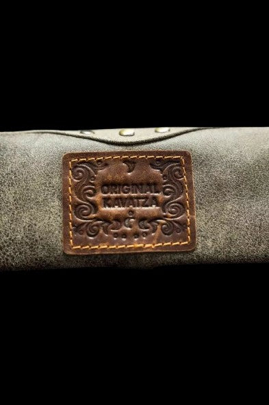 Close-up of a leather cannabis carrying case with a branded patch.