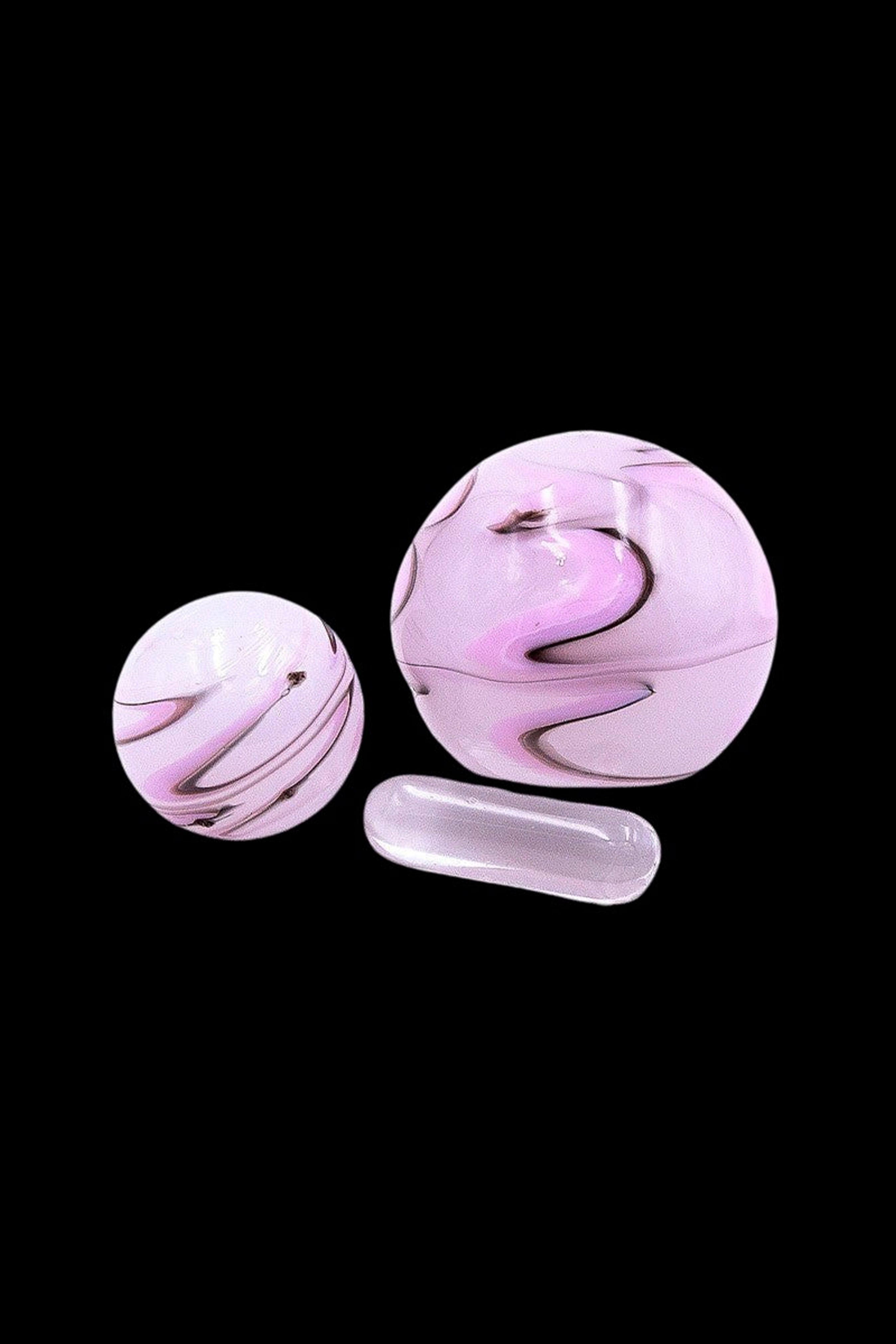 Pink glass smoking bubbles and a cylindrical pipe on a black background.
