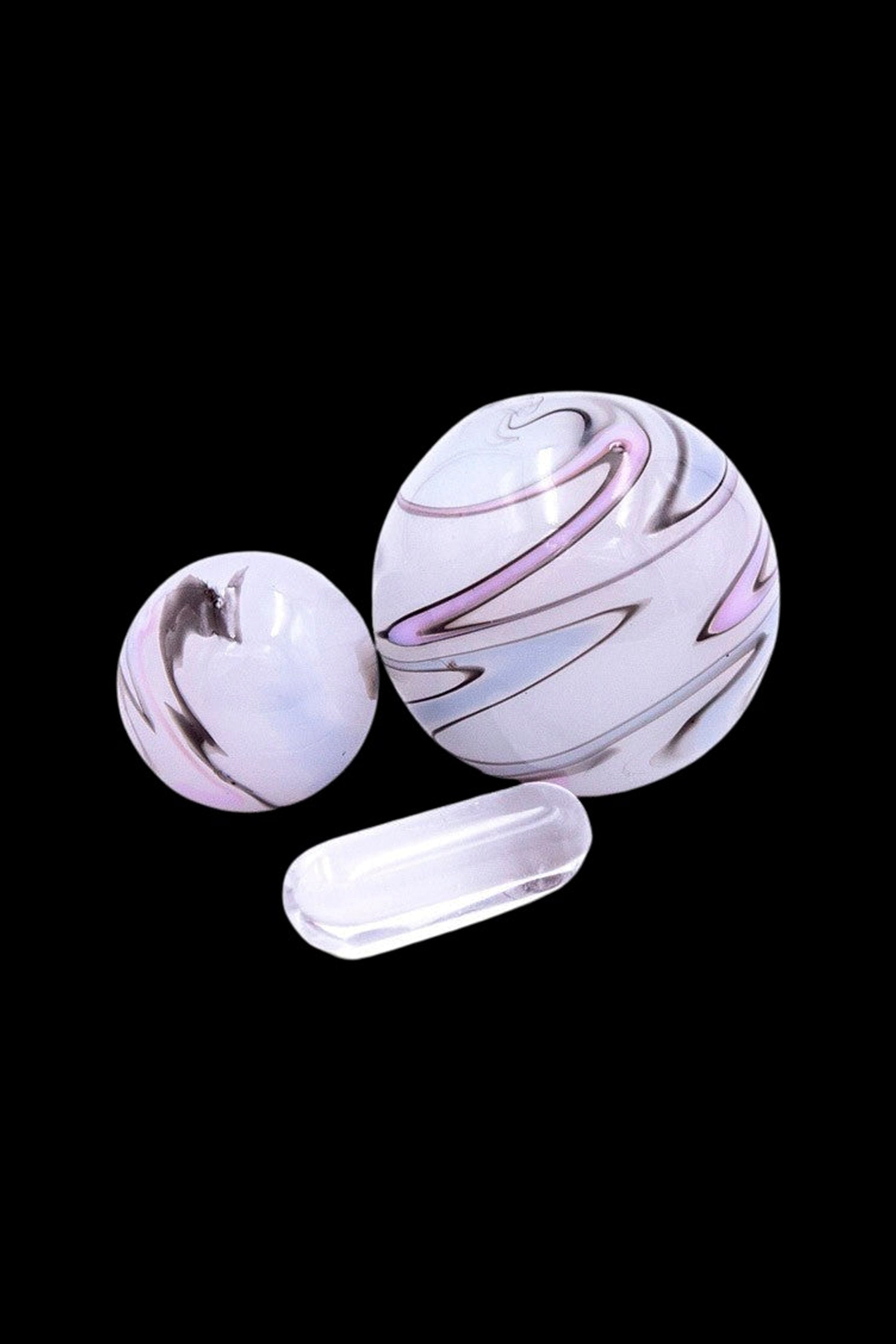 Glass marbles with lavender and white swirls, displayed against a black background.